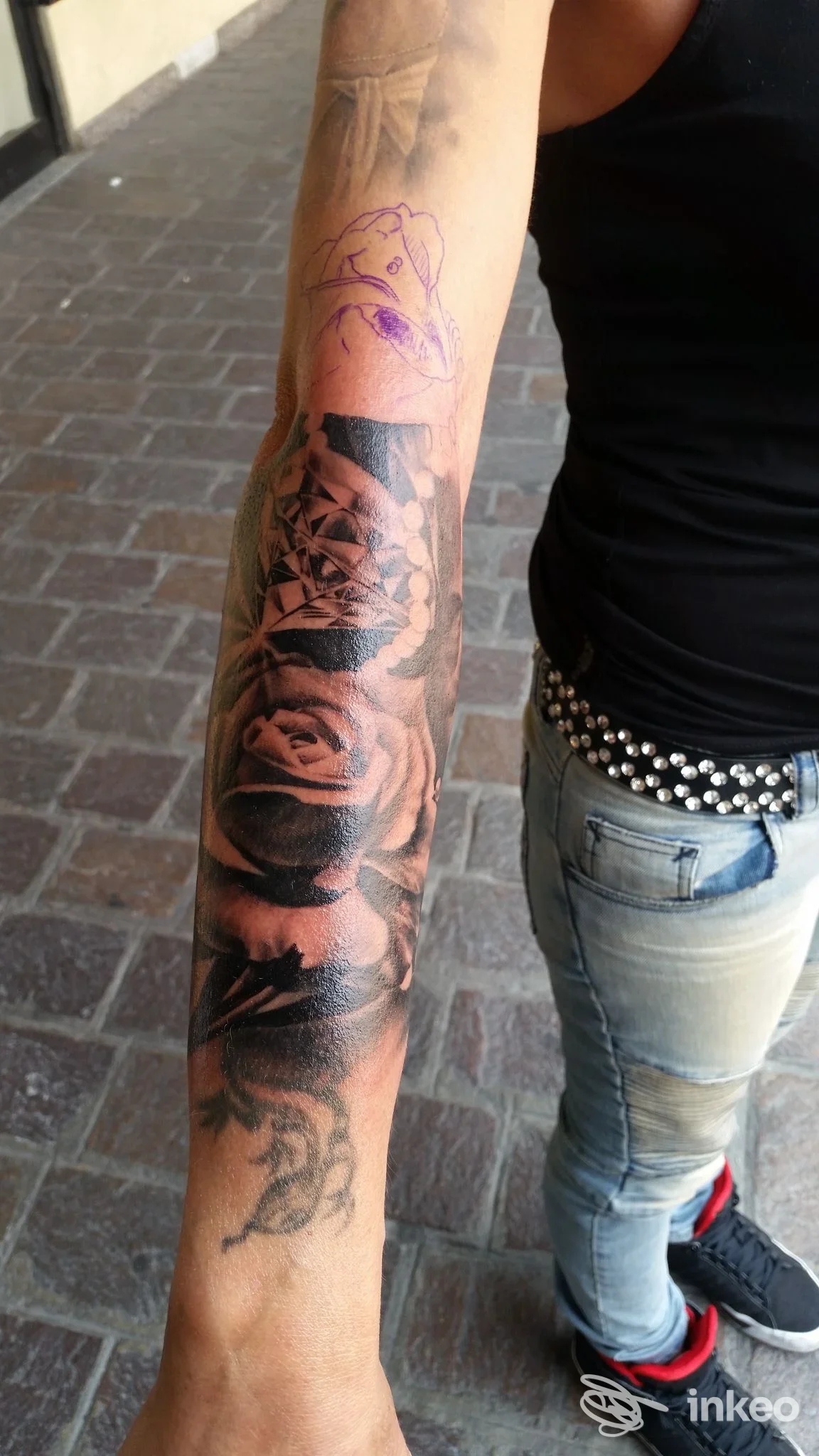 Braccio di una persona con tatuaggio completo sulla pelle: Tattoo a maniche intere visibile dal polso al braccio, realizzato dallo studio Eight Mile Tattoo a Cusano Milanino.