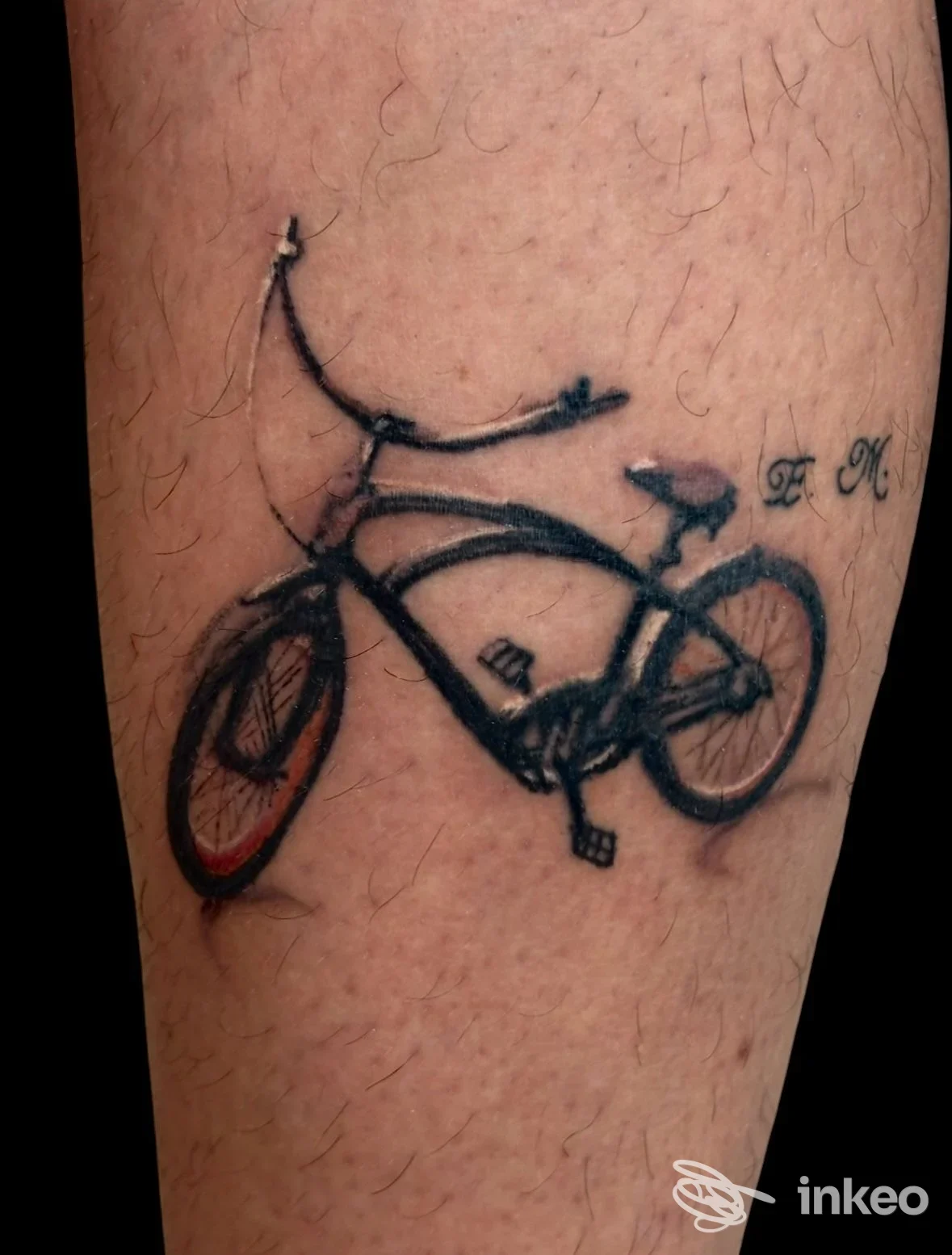 Tattoo raffigurante una bicicletta su pelle della gamba, con contorni scuri e ruote ben definite, senza testo visibile o elementi promozionali.