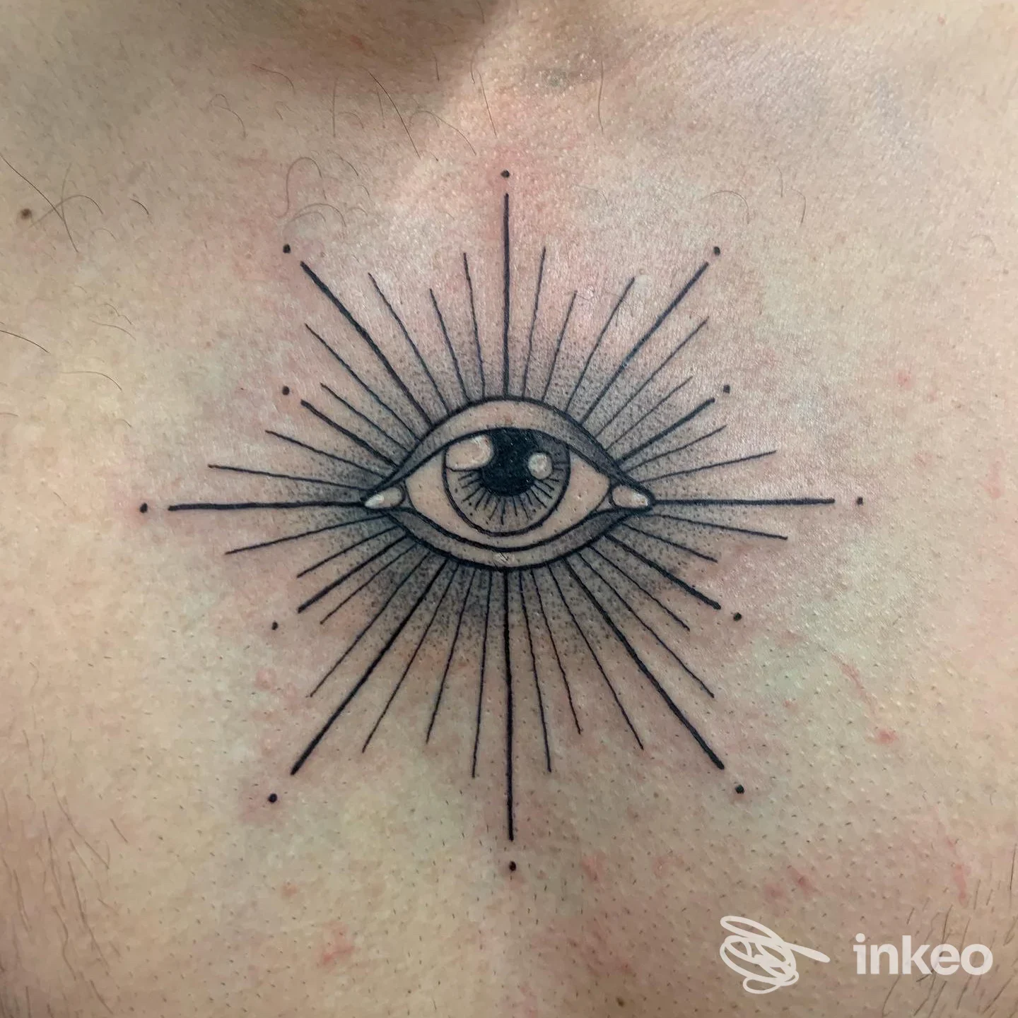 Tattoo raffigurante un occhio centrale con raggi che emanano da esso, disegnato sulla pelle, senza presenza di volto umano intero. studio P'ink Tattoo Studio.