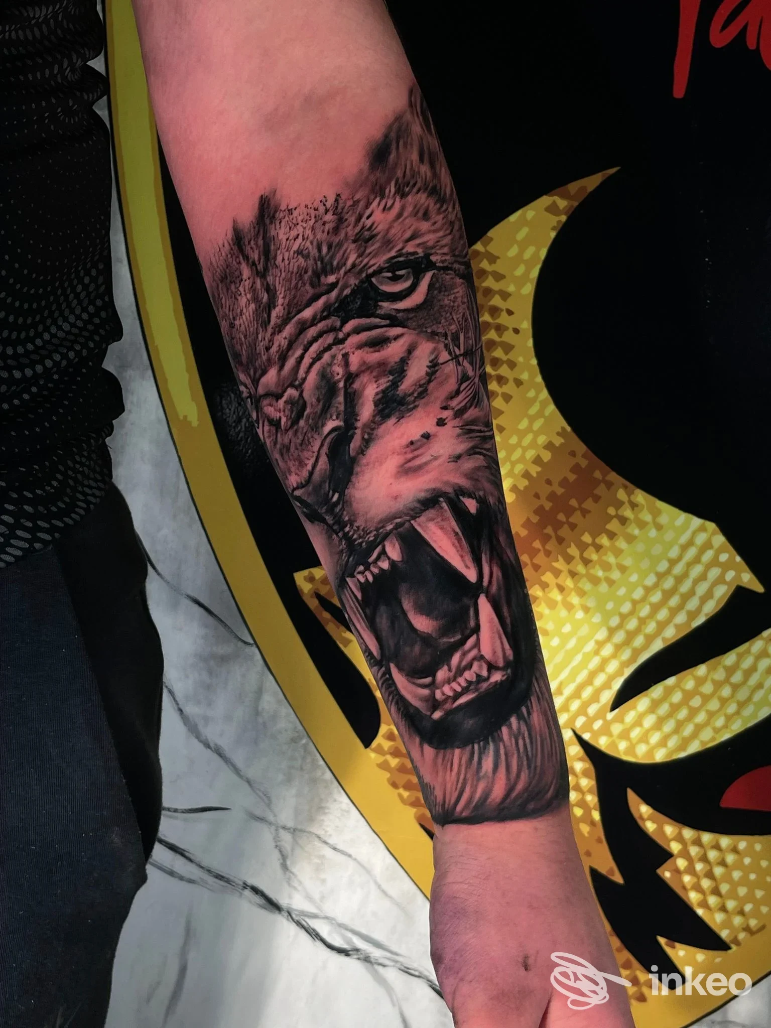 Tatuaggio realistico di un lupo che ulula sullavambraccio sinistro, con dettagli di denti e pelo. sfondo scuro, nessun volto visibile.