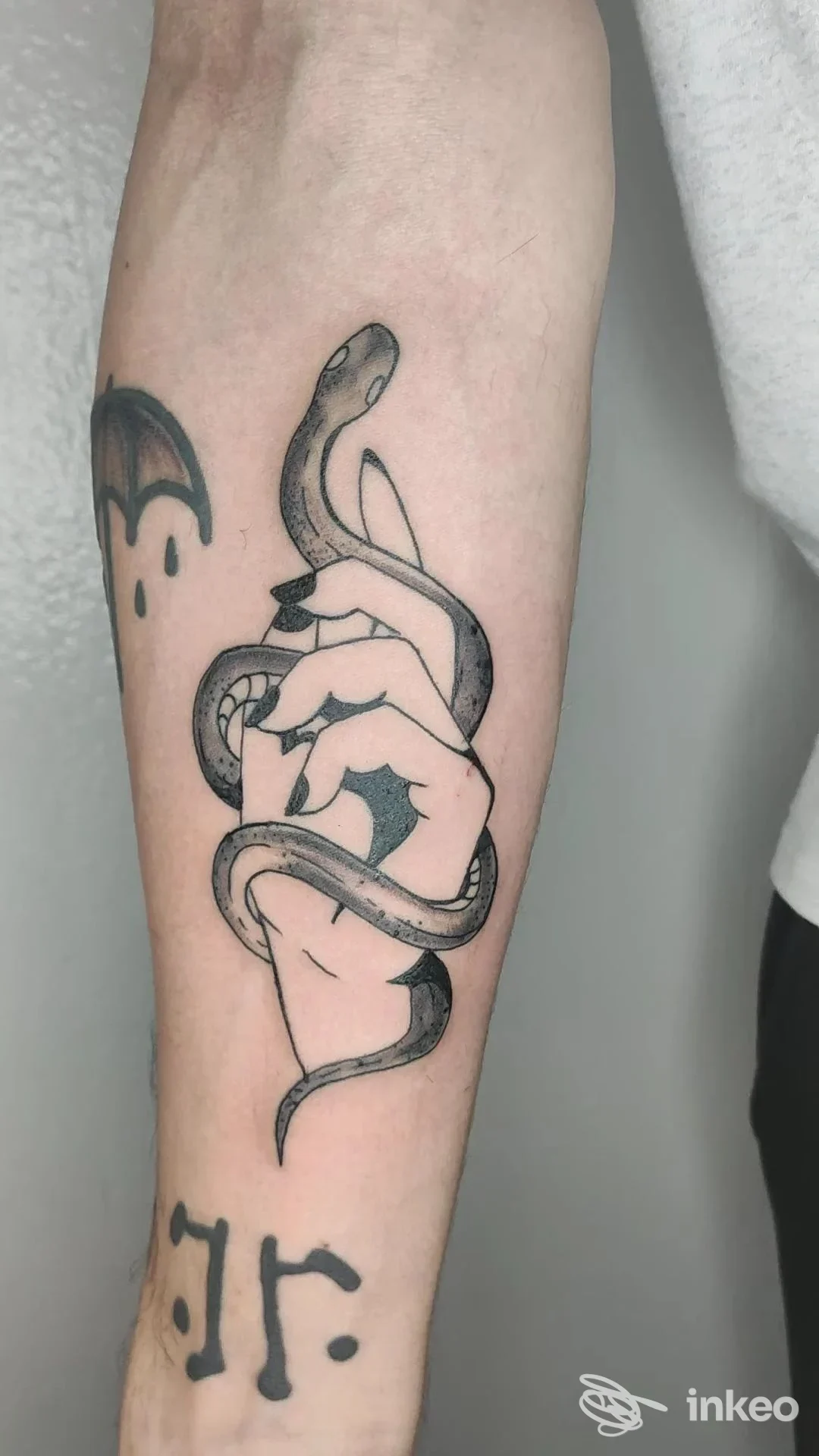Tatuaggio su avambraccio: serpente avvolto intorno a una mano in stile linework, eseguito nello studio Mario Corallo.