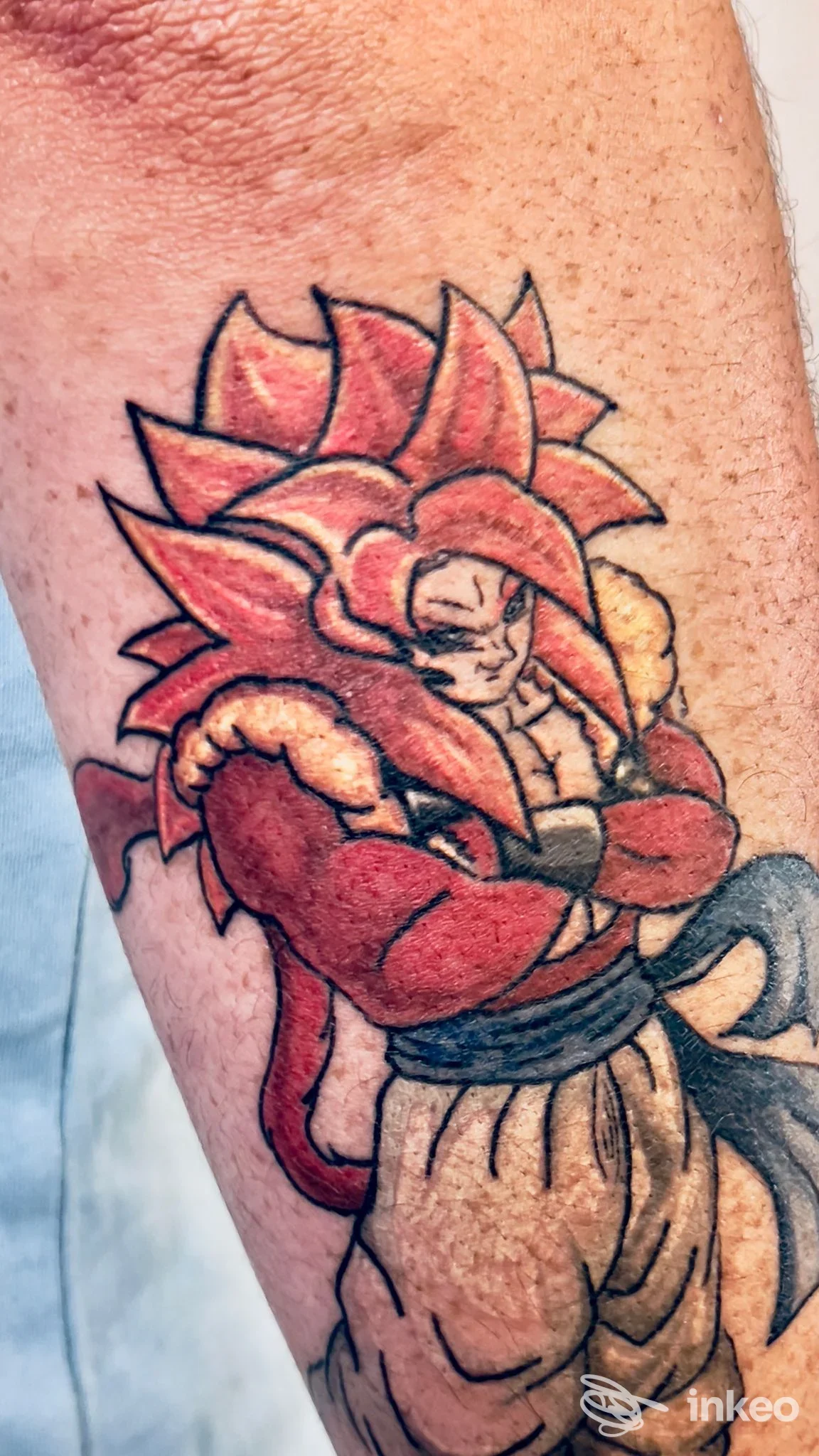 Tatuaggio su avambraccio raffigurante un guerriero muscoloso con capelli rossi, contorni netti e colori vivaci.