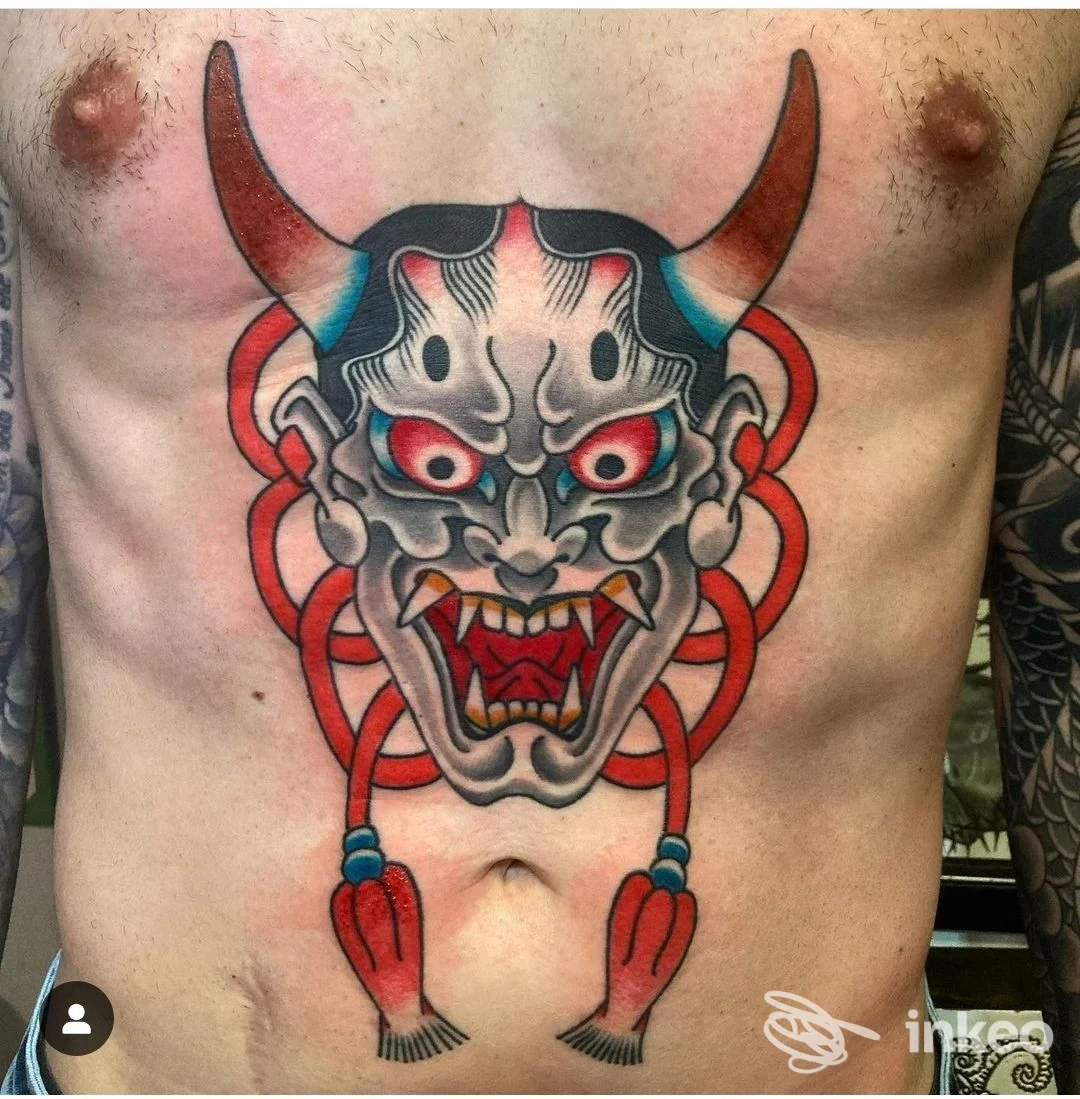 Tattoo molto grande sul torace raffigurante un demone con corna, occhi rossi e bocca aperta, contorno rosso, realizzato sulla pelle del soggetto.