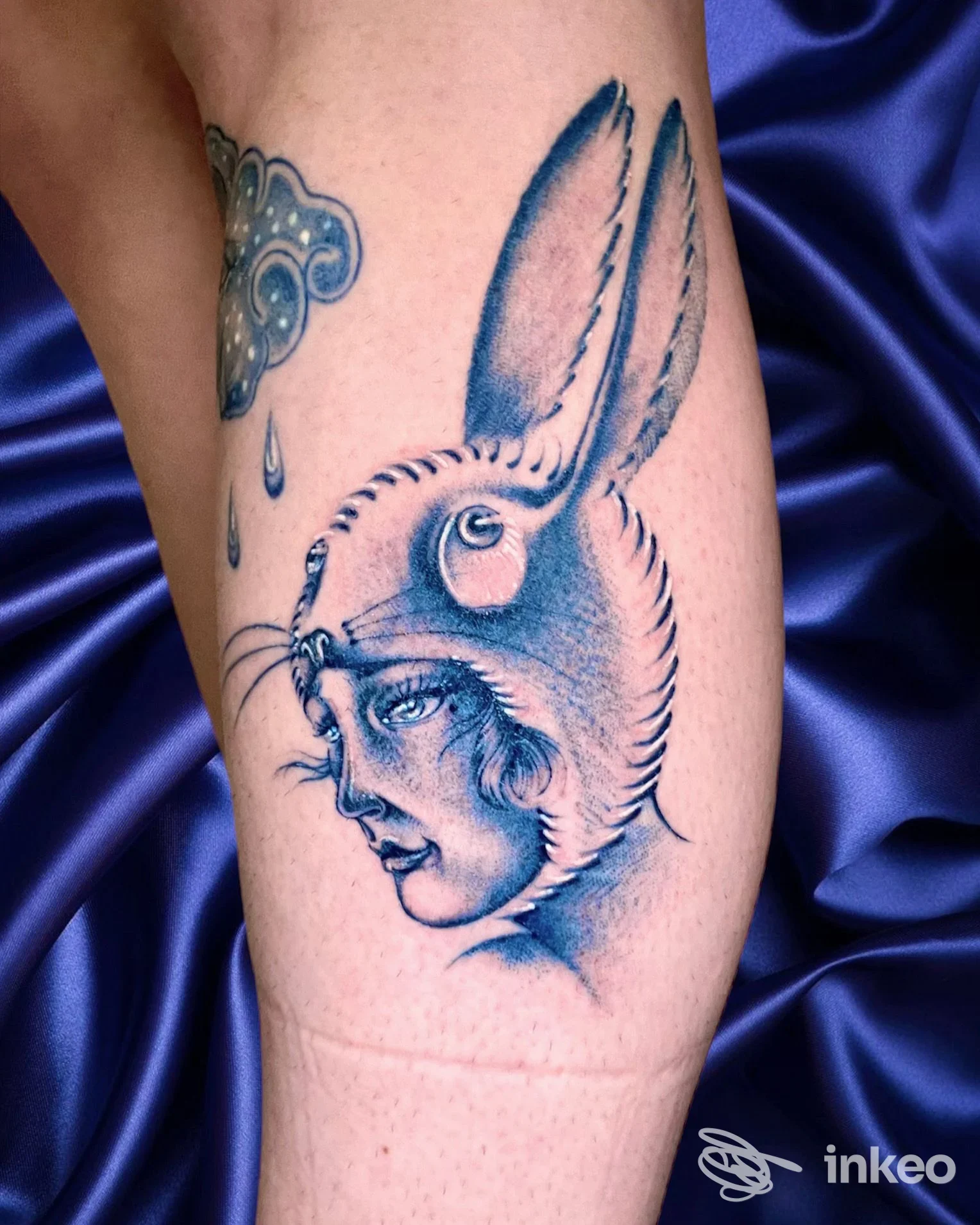 Tatuaggio su pelle raffigurante una testa di coniglio con orecchie lunghe sull'avambraccio, tonalità blu, esecuzione pulita e definita.