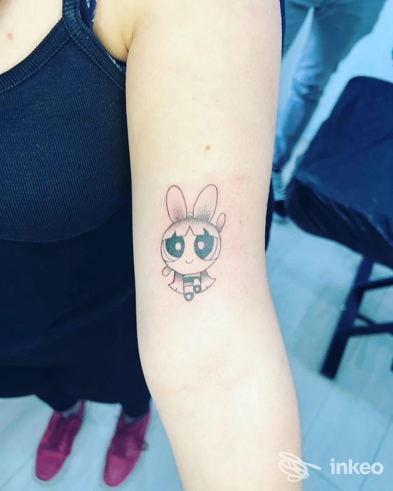 Piccolo tatuaggio su avambraccio raffigurante una mascotte coniglio con grandi occhi, orecchie rosa, contorni neri e colori tenui.