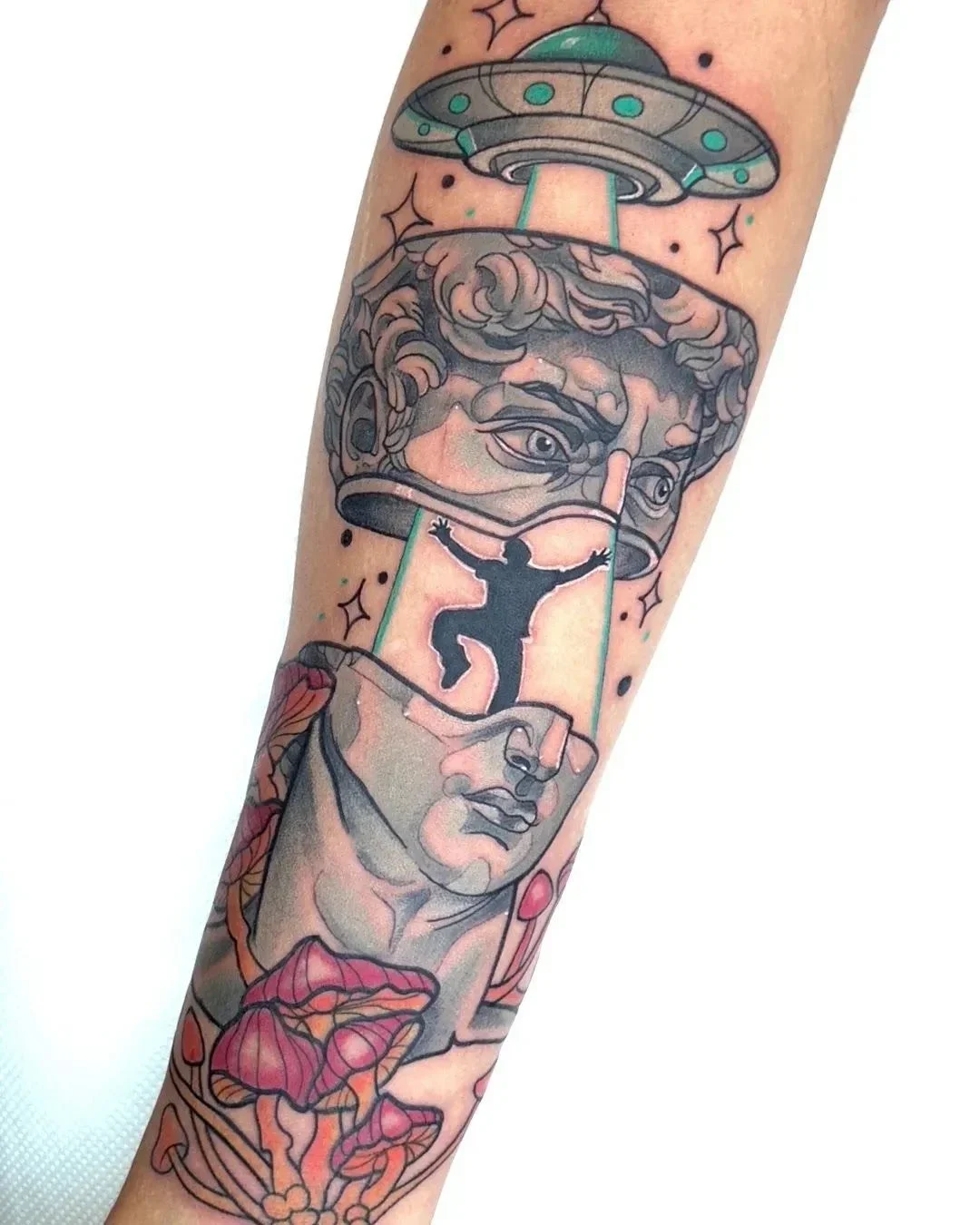 Tattoo integrale sull’avambraccio: ritratto classico di una testa in stile scultoreo con elementi astrali e figura silhouette, colori prevalentemente grigi, neri e rosa su pelle chiara. Studio The Vice, Mantova.