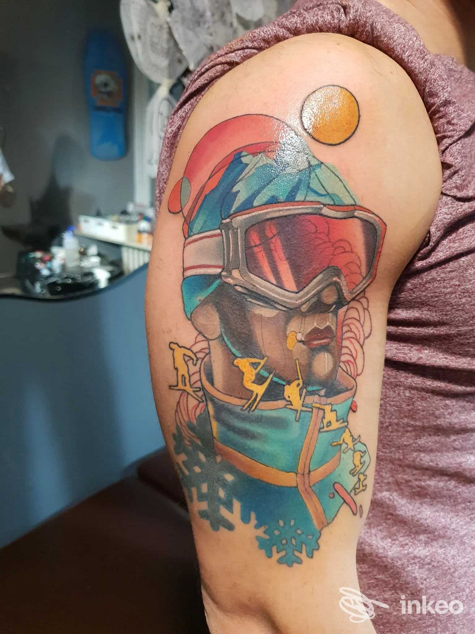 Tattoo colorato di un casco da sci su braccio superiore, stile illustrativo, senza volto visibile.