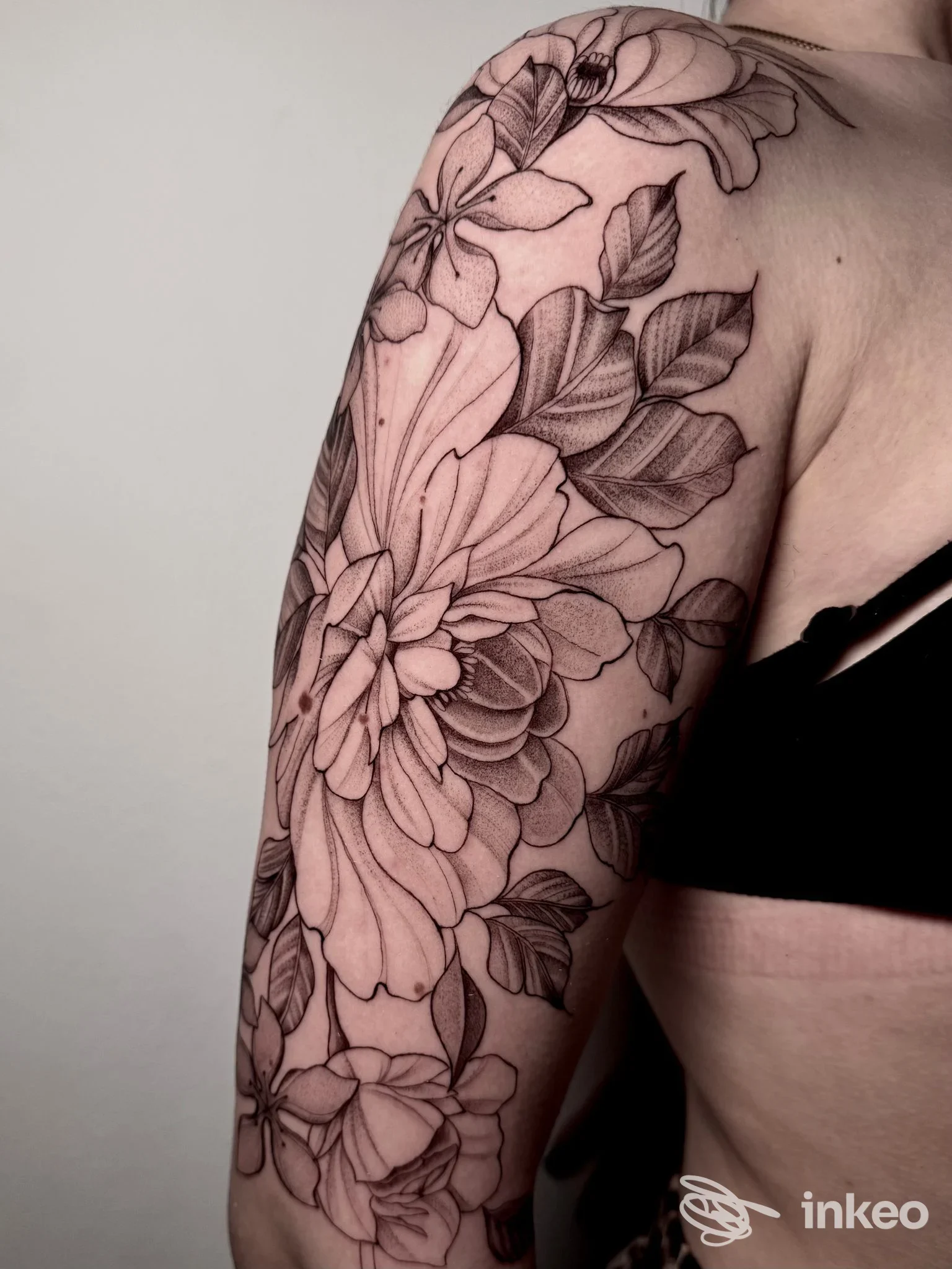 Tattoo floreale in bianco e nero su braccio visibile, realizzata su pelle, dallo studio Wonderwall Tattoo Studio.