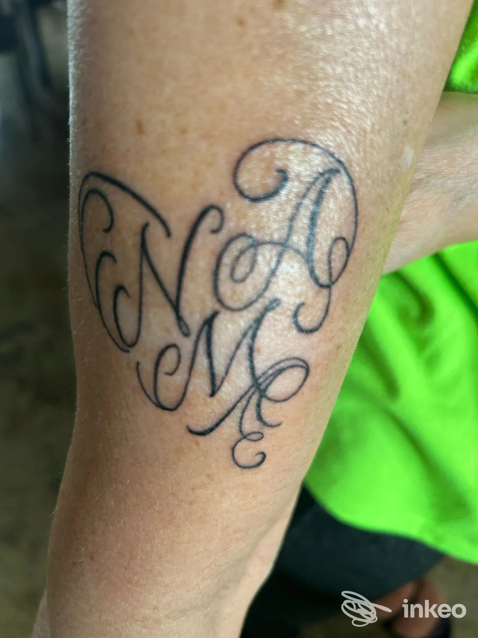 Tattoo con iniziali stilizzate e intrecciate sul braccio, realizzato in uno studio a Bonate Sotto, Incioster.