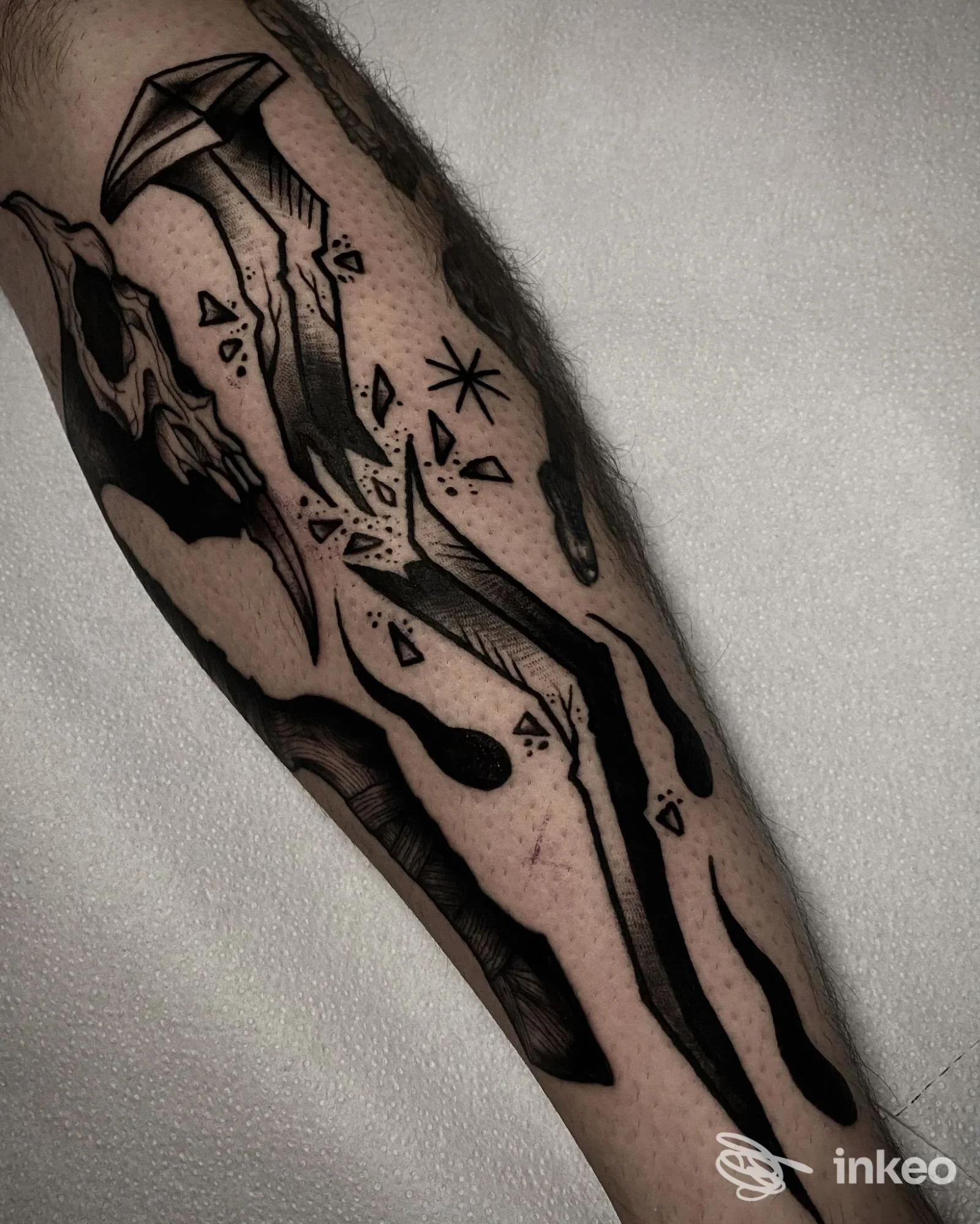 Braccio con tatuaggio nero in stile linework astratto su pelle, scatto singolo dell’avambraccio, senza volto visibile.