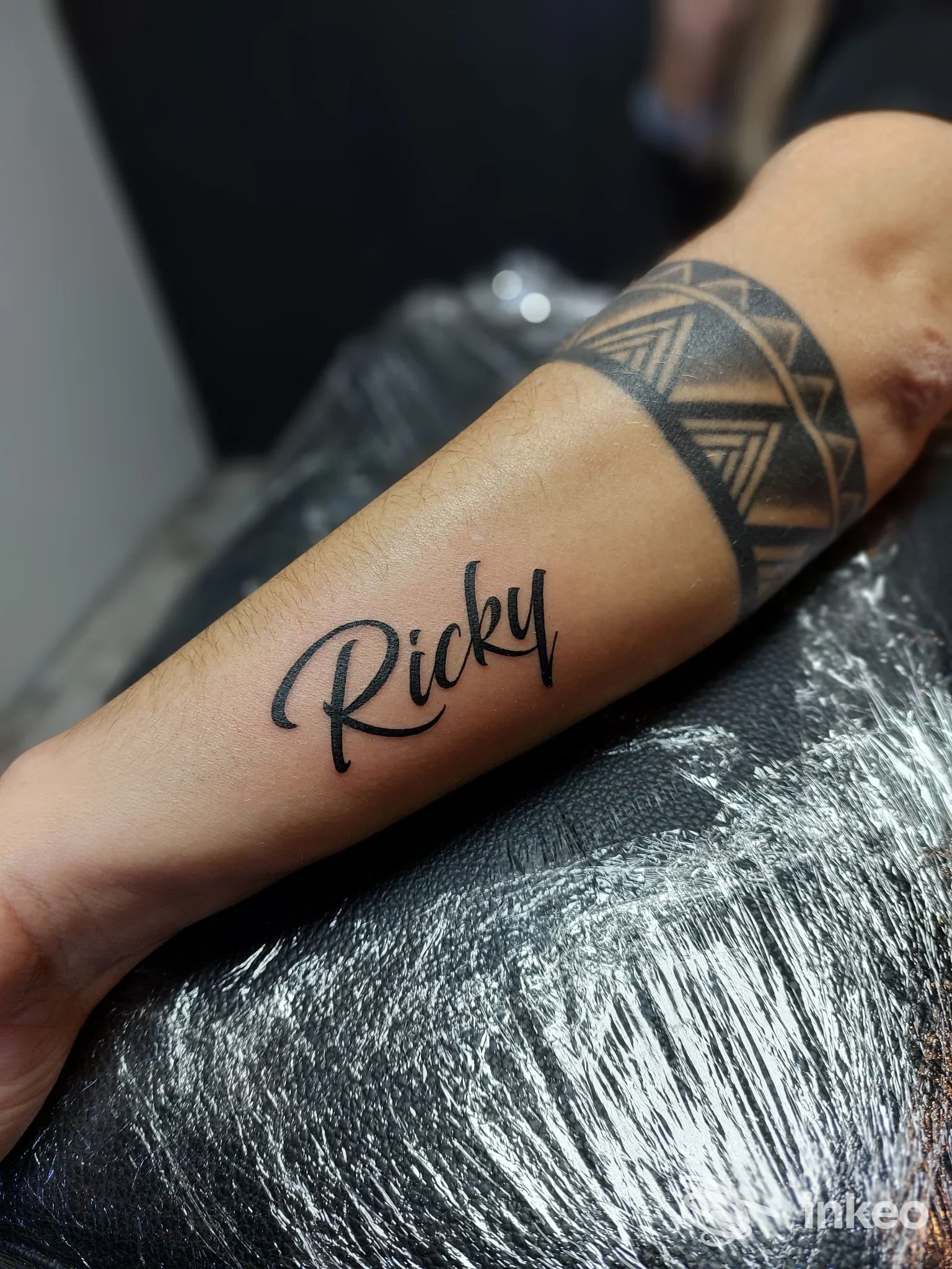Braccio sinistro con tatuaggio: nome Ricky in lettering eleganti e banda geometrica nera poco sotto, tatuaggio su pelle verificato presso Gia Tattoo a Seregno.