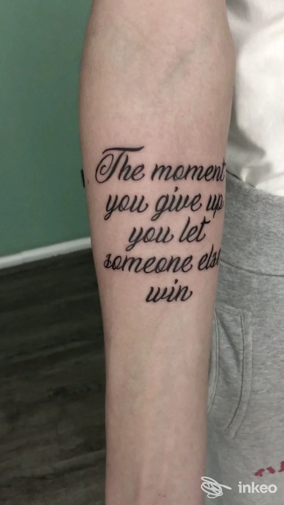 Tatuaggio in caratteri corsivi neri sull'avambraccio, realizzato direttamente sulla pelle, senza volto visibile e nessun overlay o testo promozionale visibile.