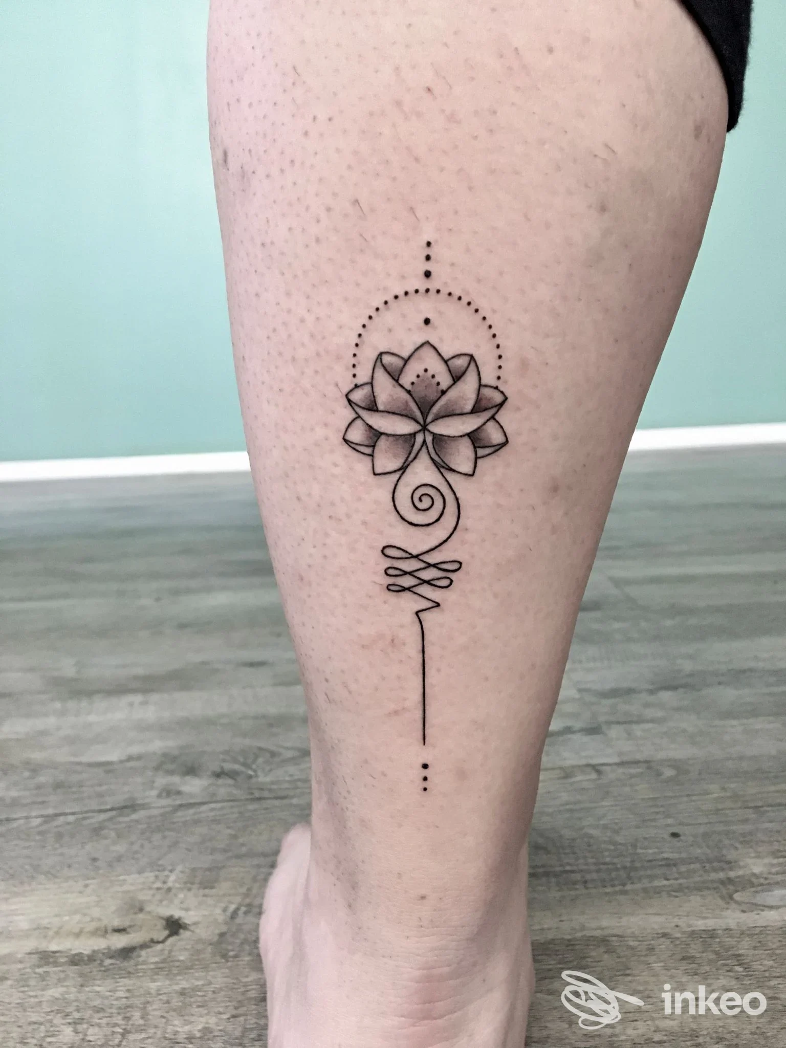 Tattoo sul polpaccio raffigurante una rosa stilizzata con elementi geometrici e linee decorative, eseguito in nero su pelle chiara.