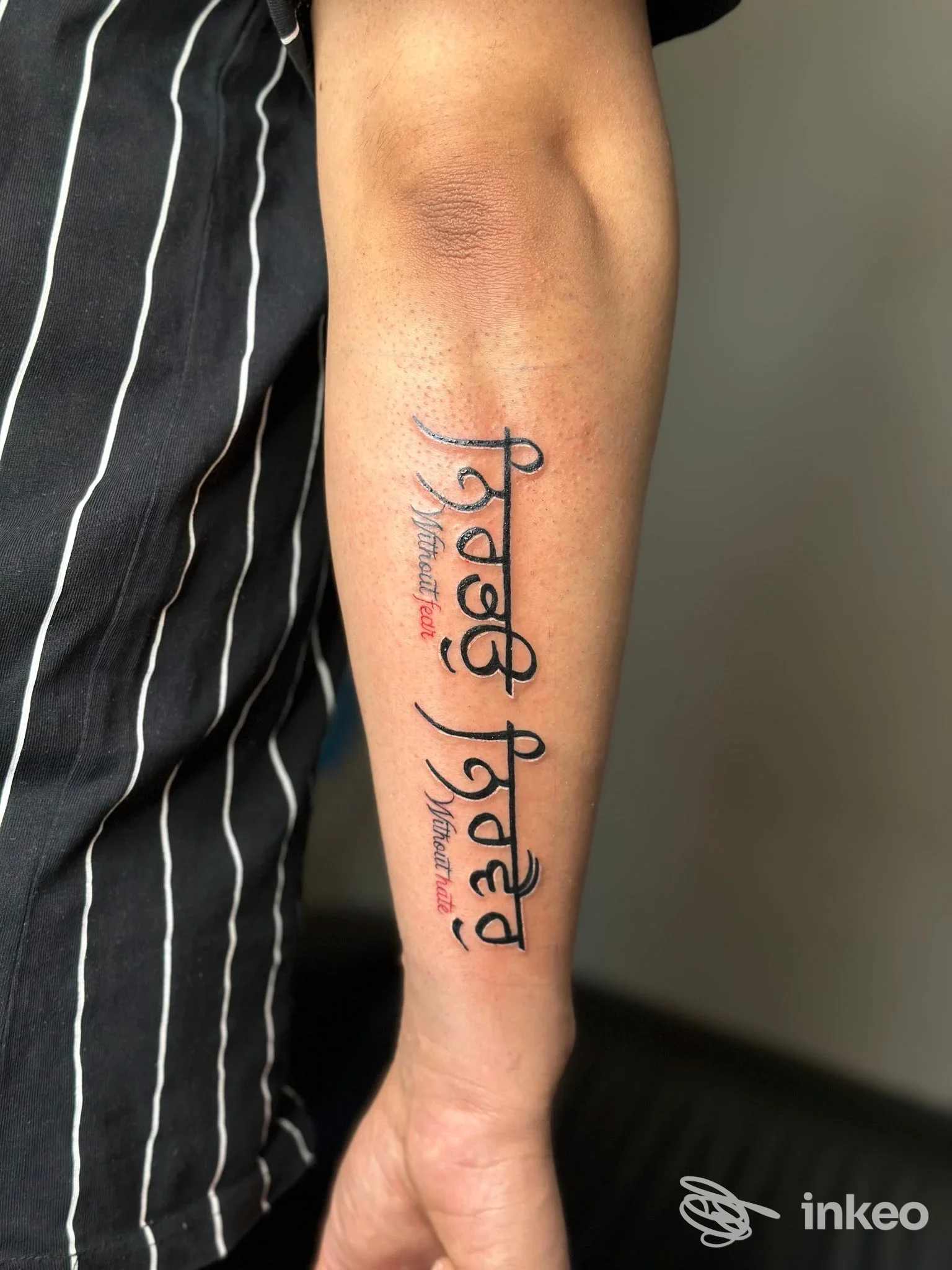 Braccio con tatuaggio verticale dal testo decorativo, firma e stile calligrafico, eseguito nello studio Cumar Tattoo a Manerbio.