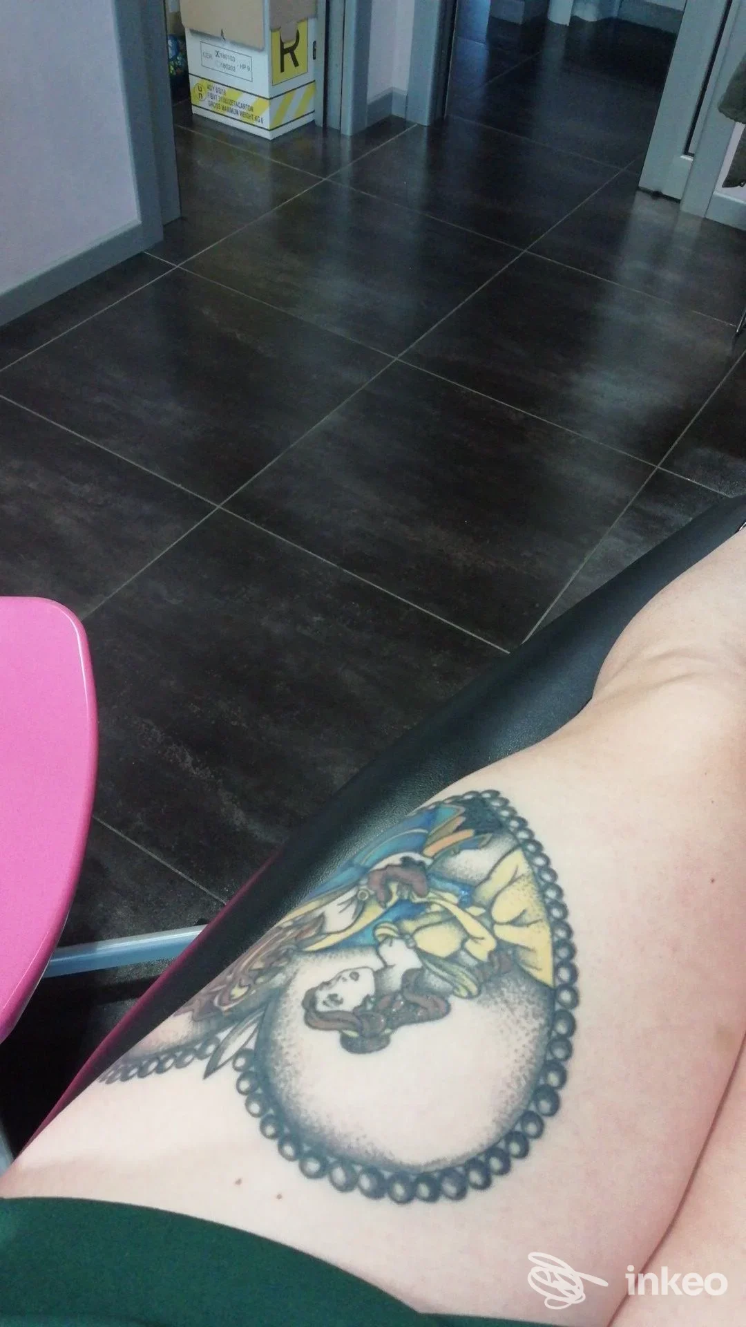 Foto di una gamba con tatuaggio colorato e ornamenti neri, visibile vicino al ginocchio; primo piano sull’arto senza visibile volto.