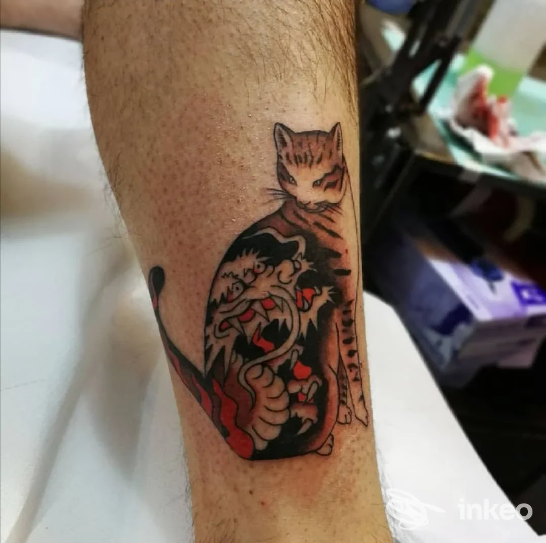 Tatuaggio visibile sull’avambraccio: gatto stilizzato su una figura nera con dettagli rossi, eseguito da Baldo Tattoo a Varese.