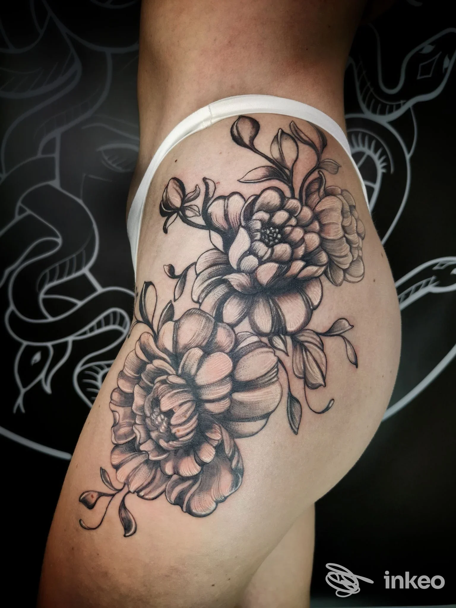Tatuaggio floreale su glutei di una persona, realizzato da Bleedink Tattoo a Brescia, in studio.