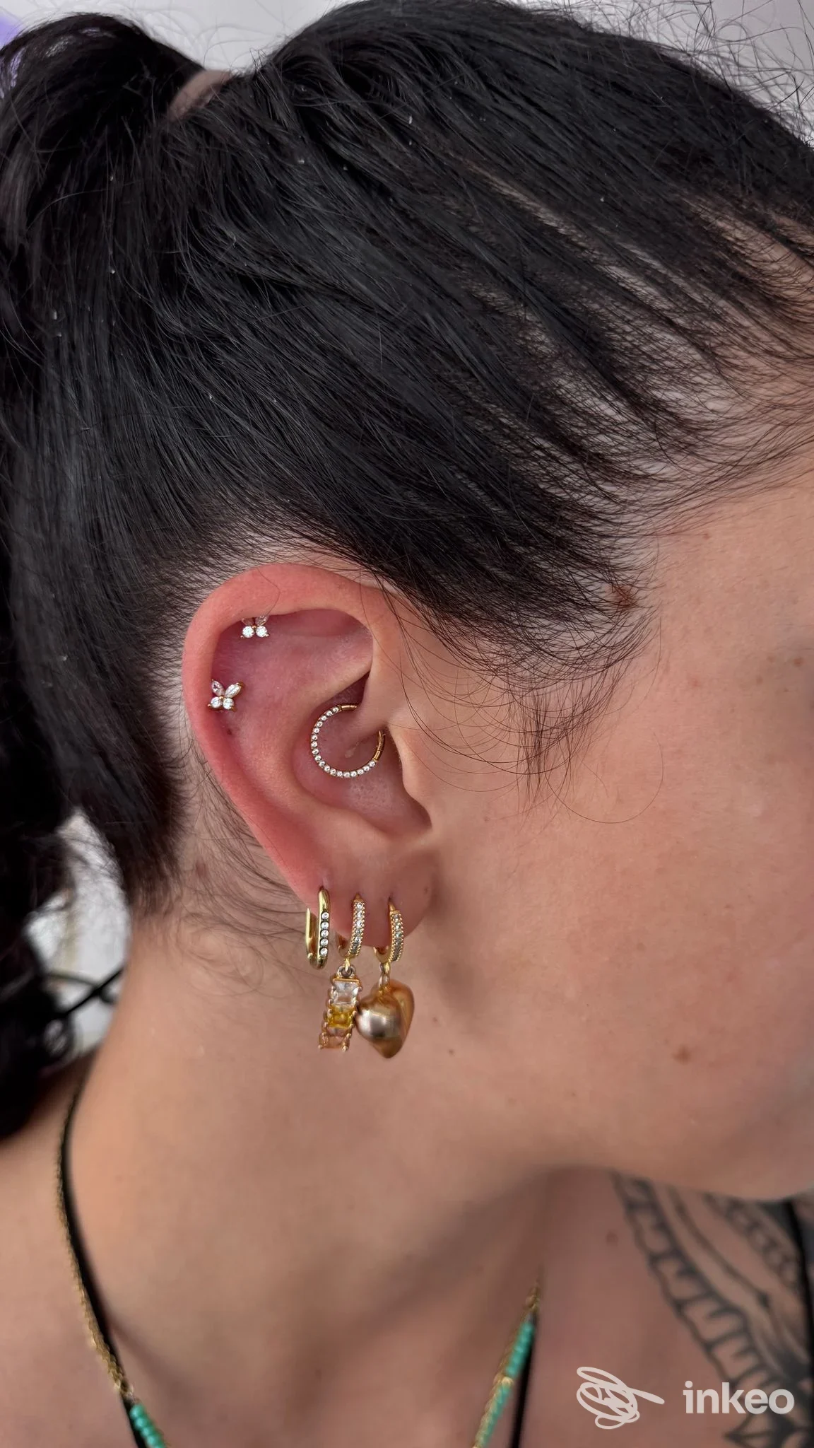Soggiorno joy: piercing sull'orecchio visibile in primo piano con orecchini e anelli in metallo, scatto della parte laterale della testa nello studio Joy Project Studio.