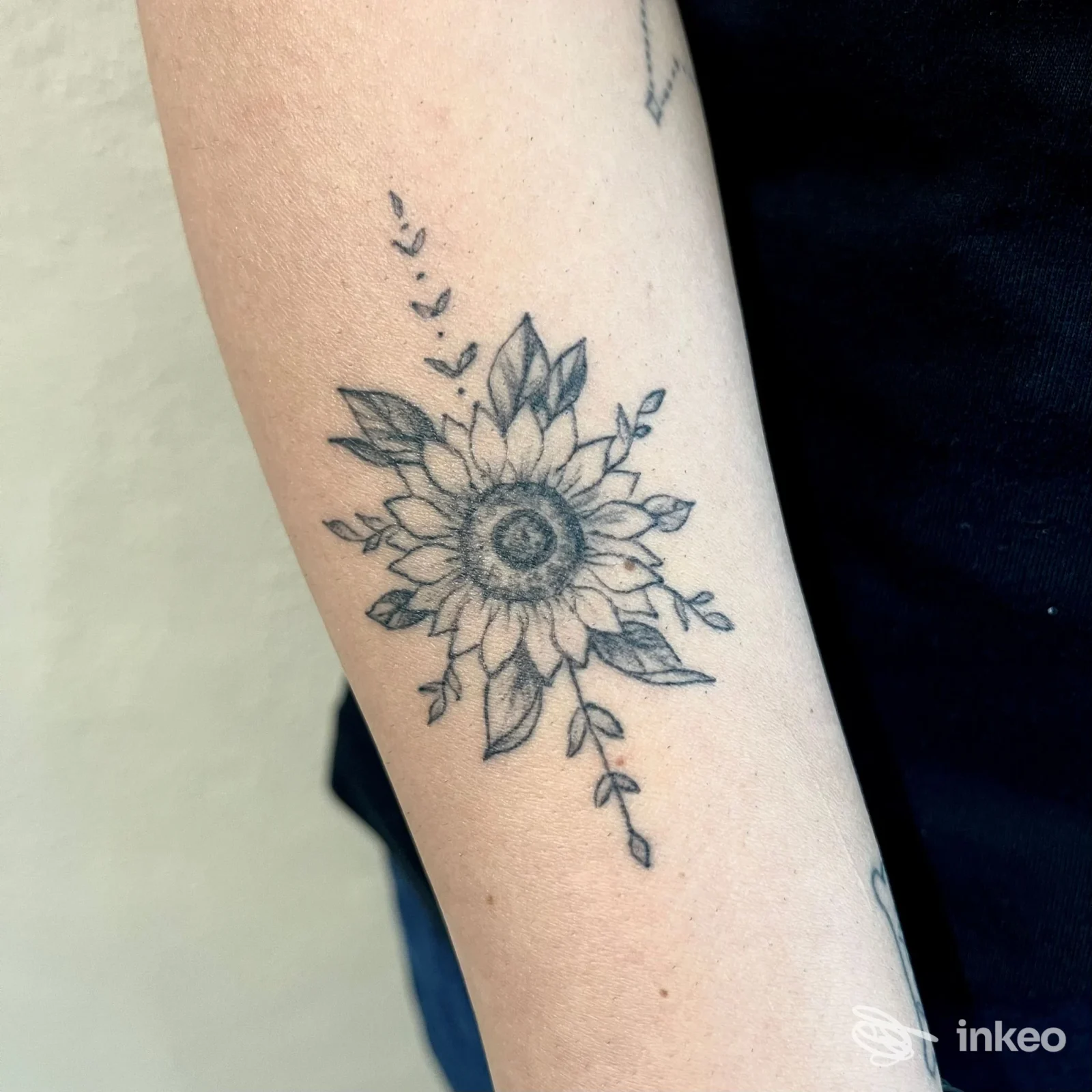 Tattoo reale sul braccio raffigurante un fiore tipo girasole, eseguito presso Feder Tattoo Studio a Lardirago, senza volto visibile.