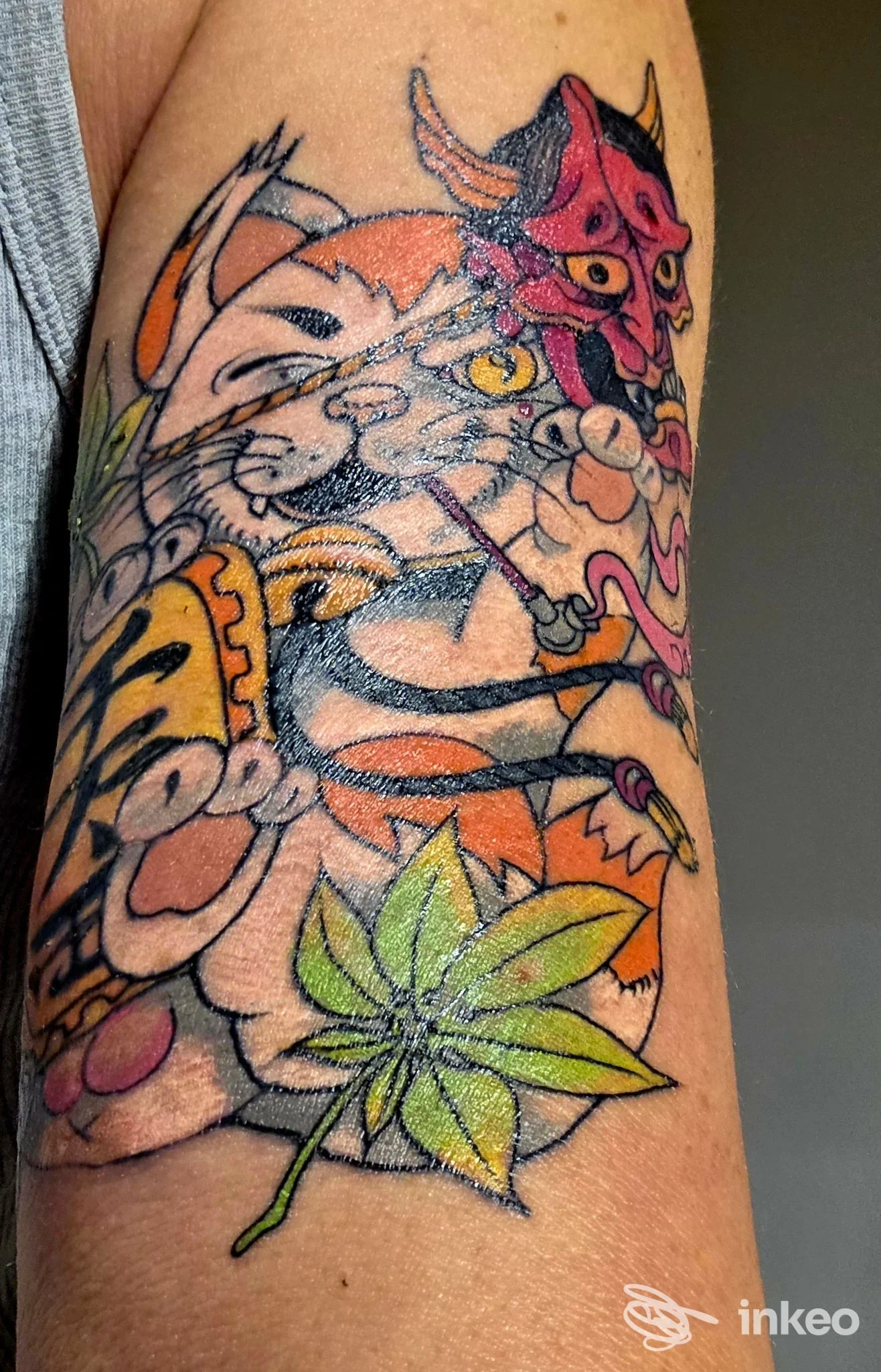 Tattoo colorato su braccio con personaggi cartooneschi di animali e elementi floreali, realizzato direttamente sulla pelle.