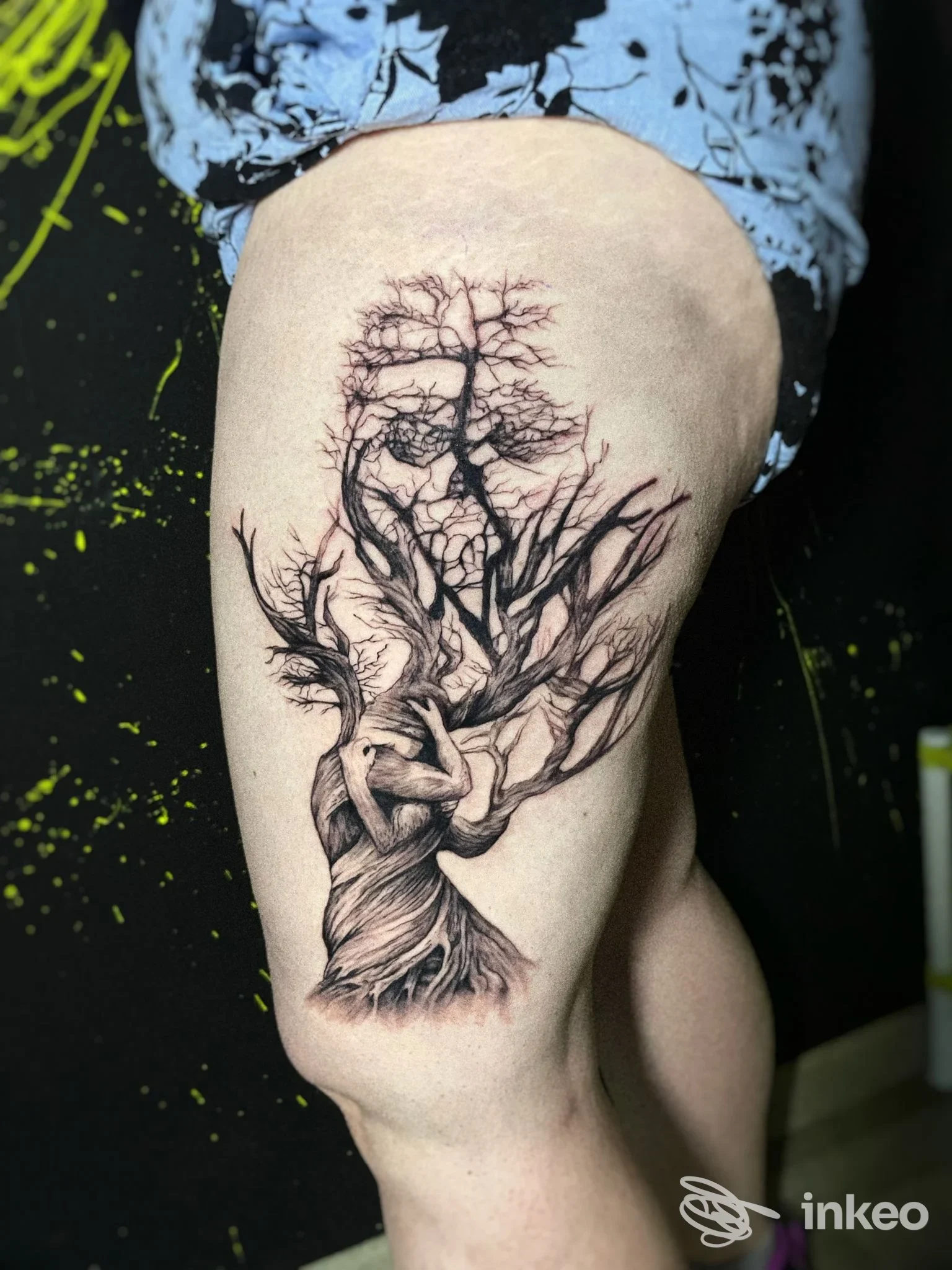 Tattoo su coscia sinistra raffigurante un albero con radici fertili e rami intricati in stile linework, eseguito su pelle chiara.