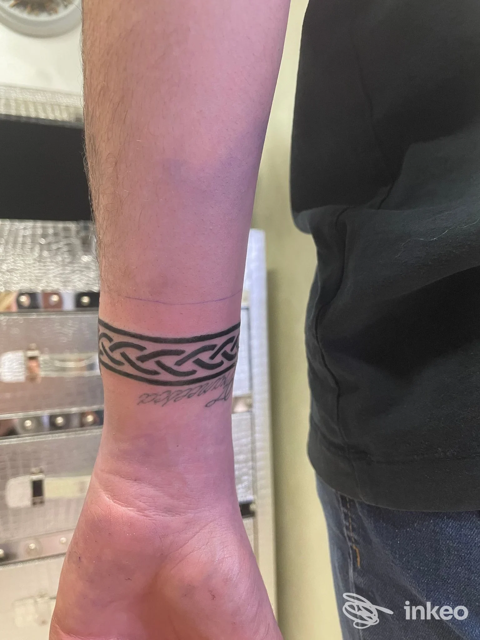 Tattoo reale al polso con motivo intrecciato circolare, visibile su avambraccio parzialmente scoperto.