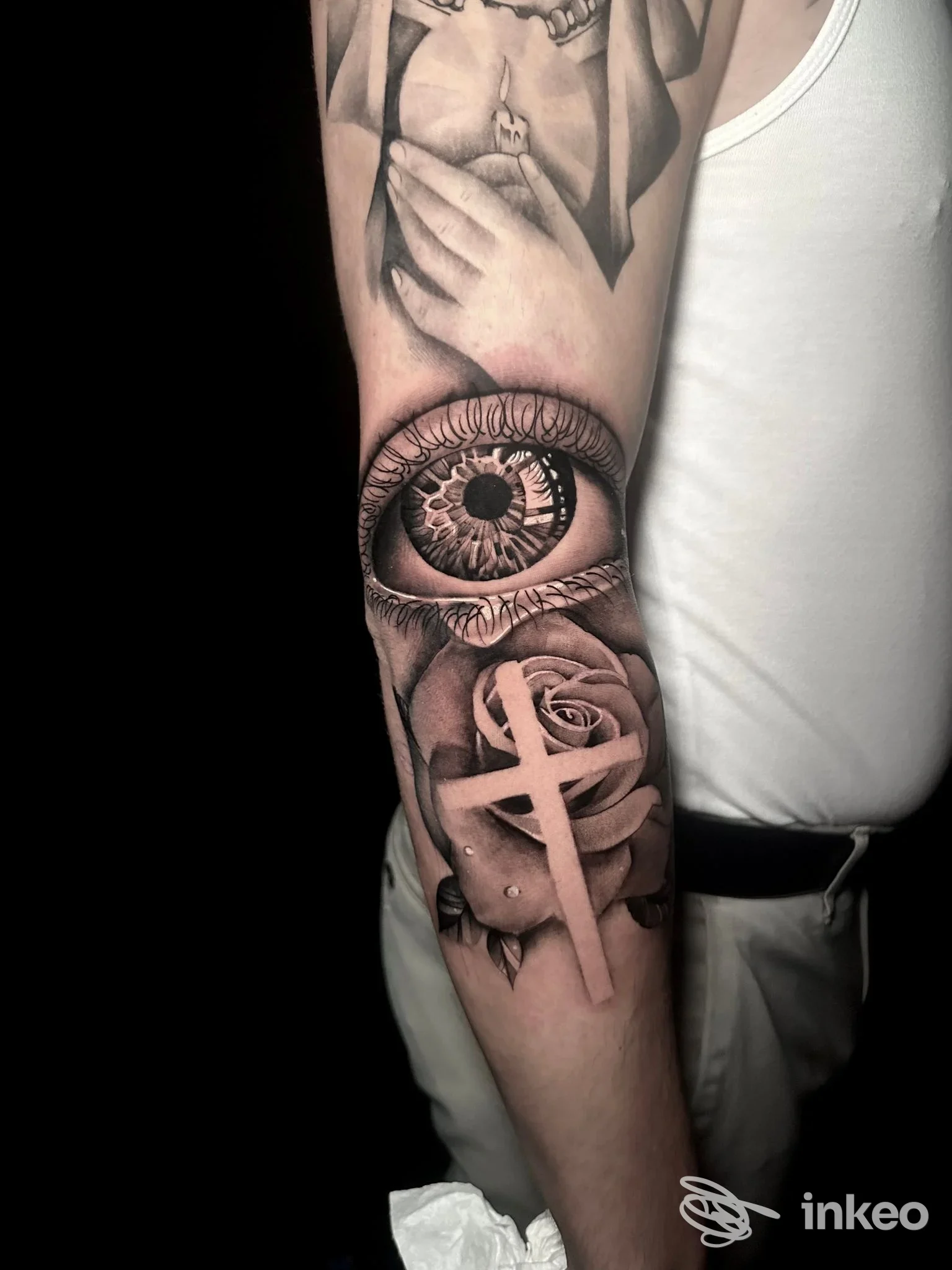 Tattoo realistico su avambraccio sinistro raffigurante occhio dettagliato e rose, realizzato da Mattblack Tattoo.