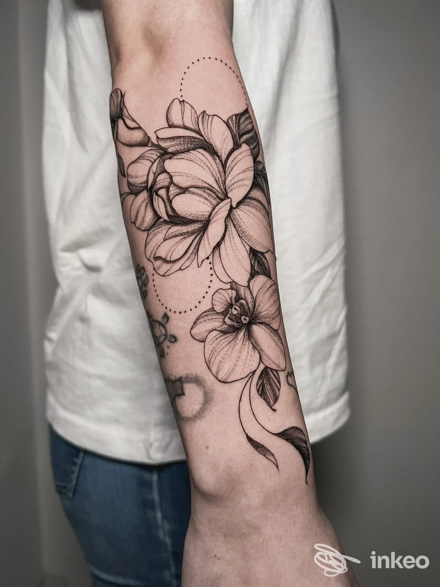 Tatuaggio floreale su avambraccio visibile su pelle umana, con linee pulite e sfumature leggere.