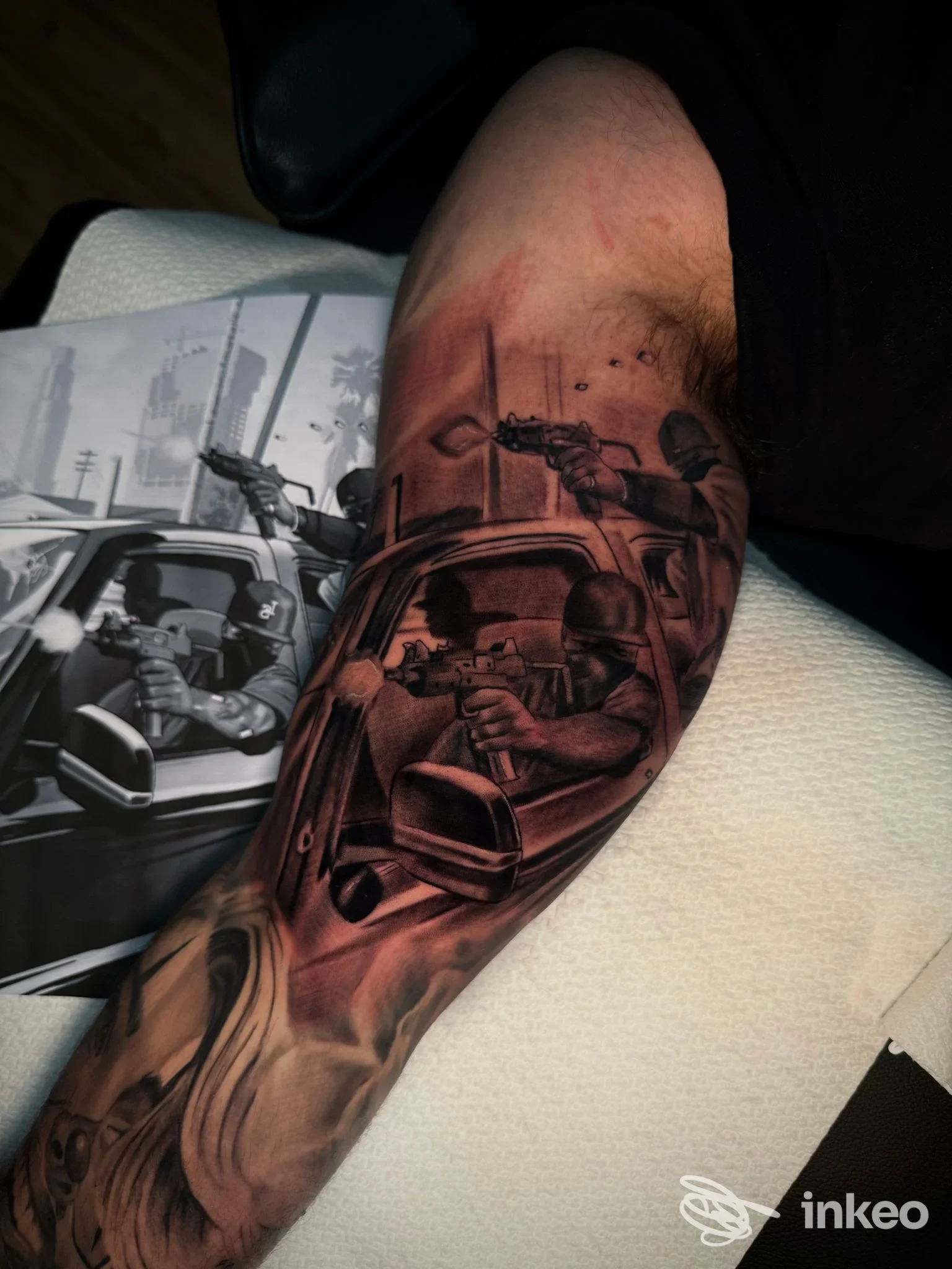 Tattoo realistico su avambraccio raffigurante una scena di sparatorie con figure armate, veicoli e paesaggio urbano, eseguito presso Jampotattoo studio.