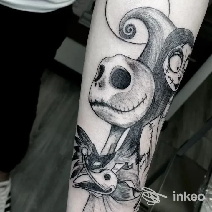 Tattoo su avambraccio raffigurante personaggi ispirati a Nightmare Before Christmas, disegno a china in bianco e nero.