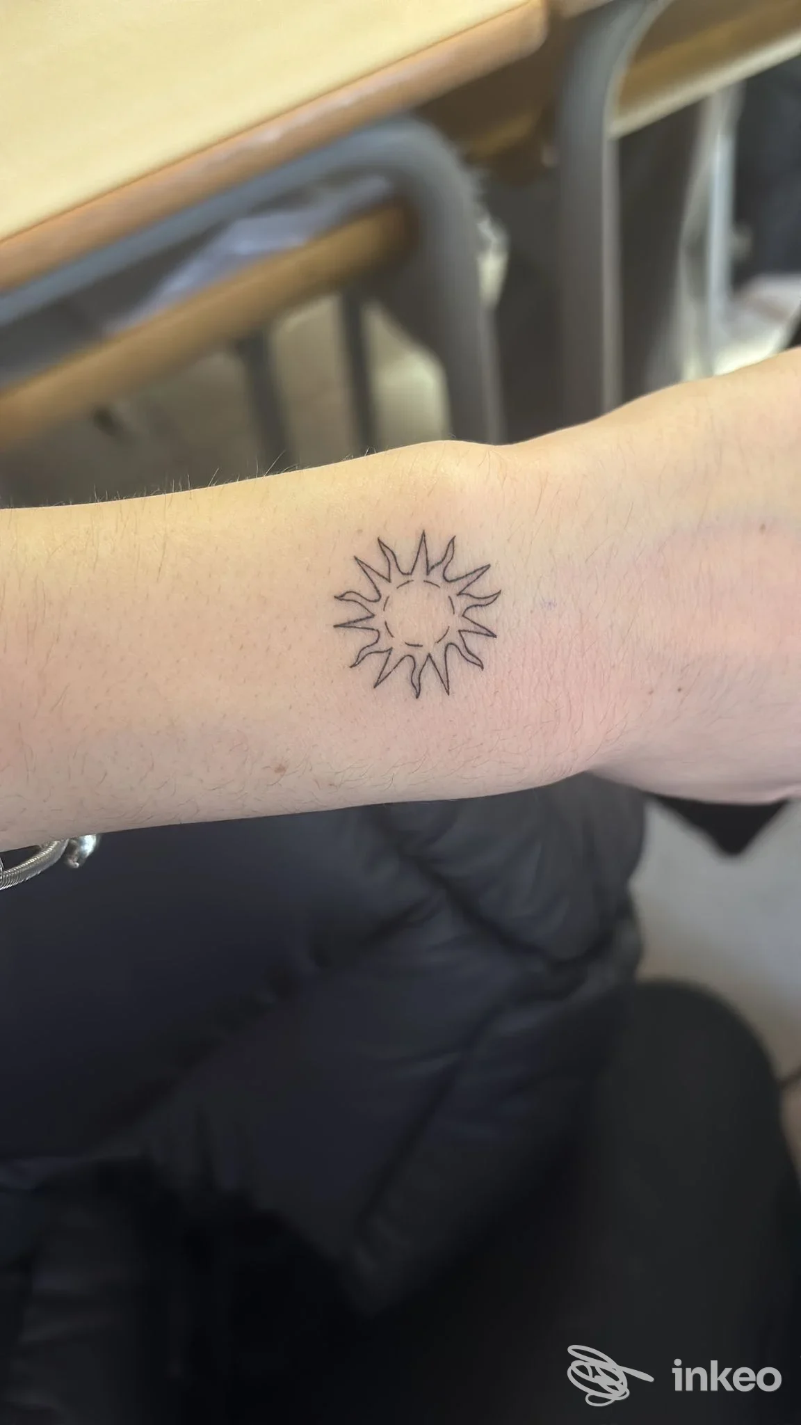 Tatuaggio a forma di sole sul polso, realizzato da EMV Studio a Brescia.