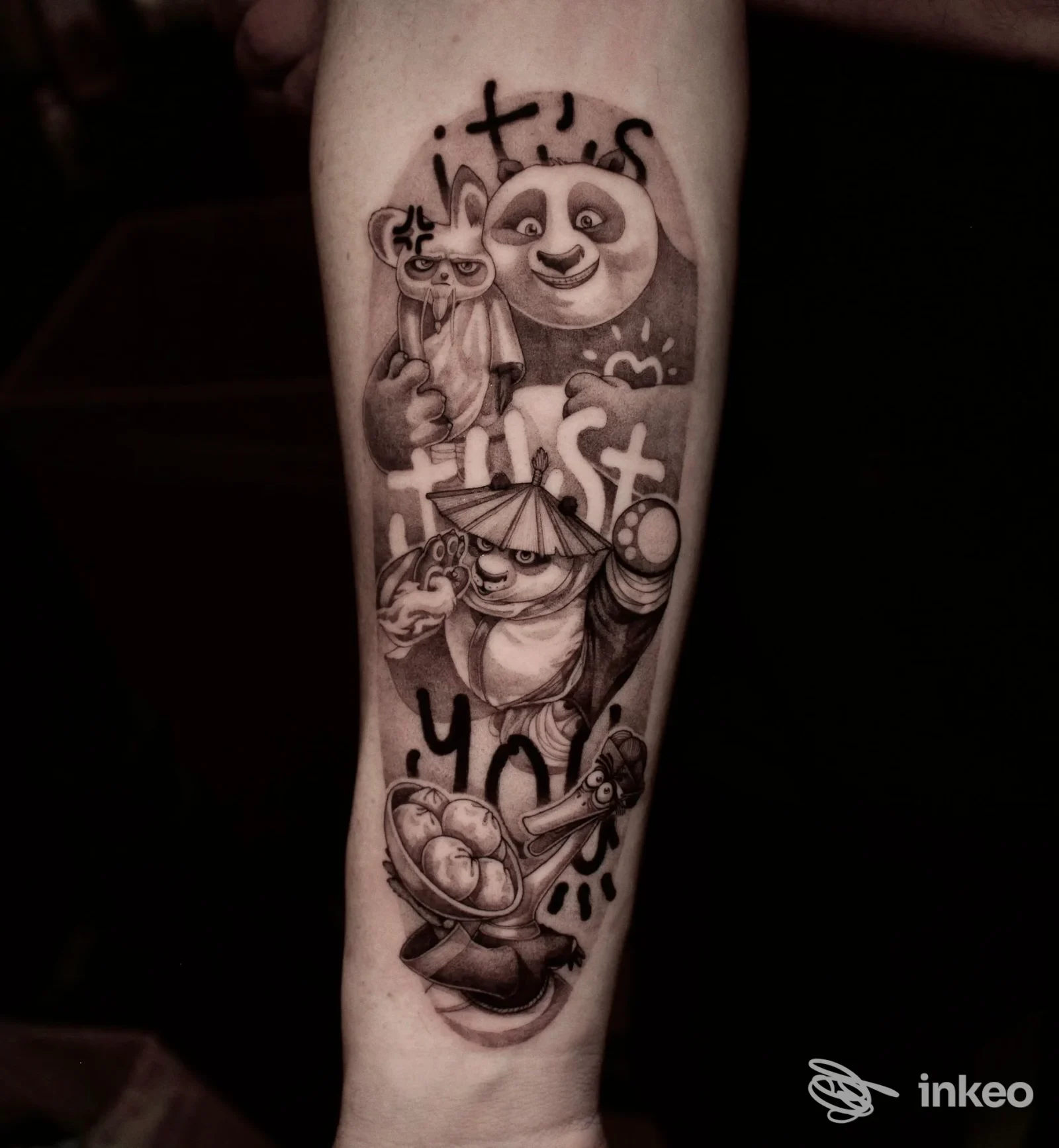 Tattoo in bianco e nero sull'avambraccio raffigurante panda e personaggi fantasy, con sfumature grafiche e didascalie stilizzate.