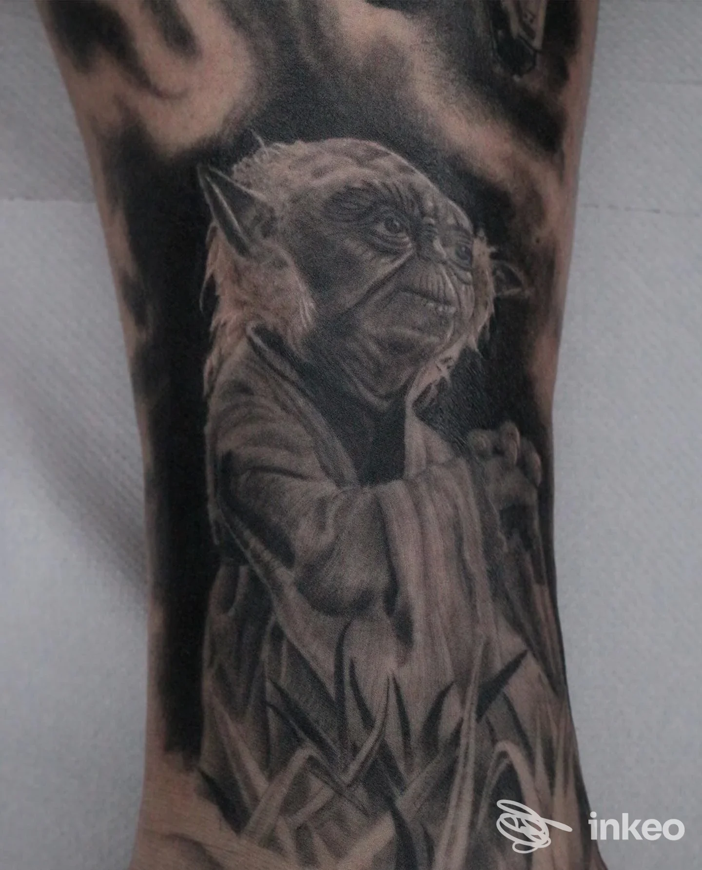 Tatuaggio realistico in bianco e nero raffigurante Yoda su pelle umana, visibile sull’avambraccio senza testo o elementi di social.
