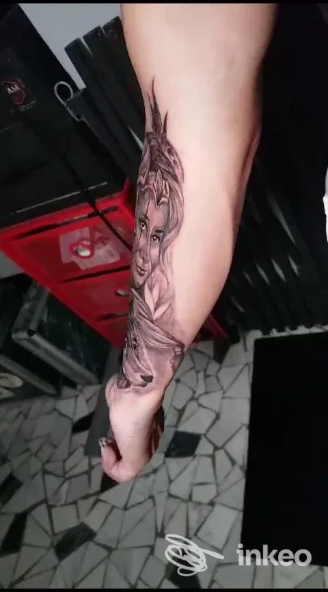 Tatuaggio realistico sul braccio raffigurante un volto femminile con elementi floreali in tonalità nere, realizzato nello studio Made in Milano Tattoo a Milano.