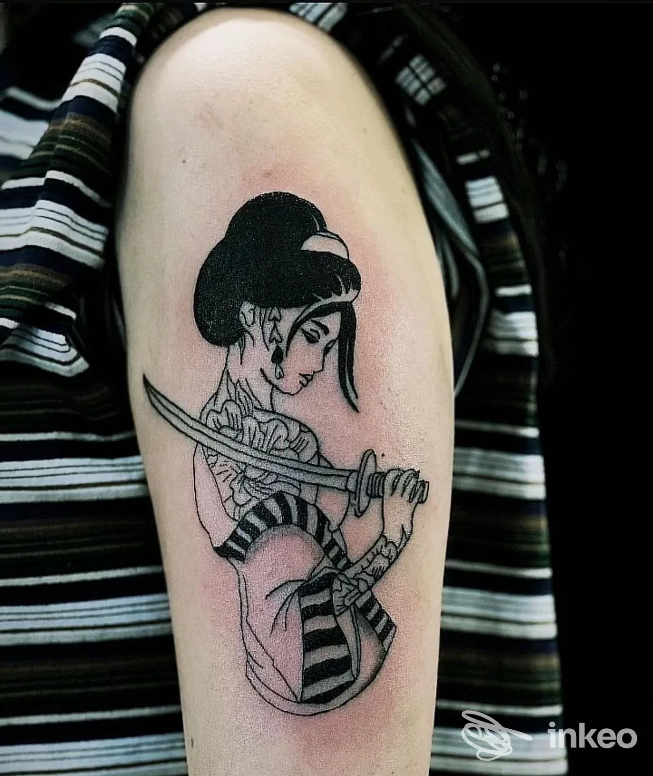 Tattoo raffigurante geisha con spada sull'avambraccio, realizzato sulla pelle di una persona, senza testo o watermark visibili.