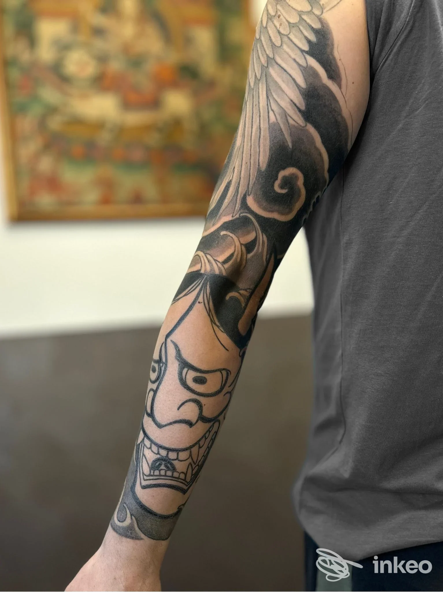 Braccio sinistro con tatuaggio a manica scuro: motivi alari e figure astratte, tatuaggio completo sull’avambraccio. Studio Elevenink Tattoo, città non specificata.