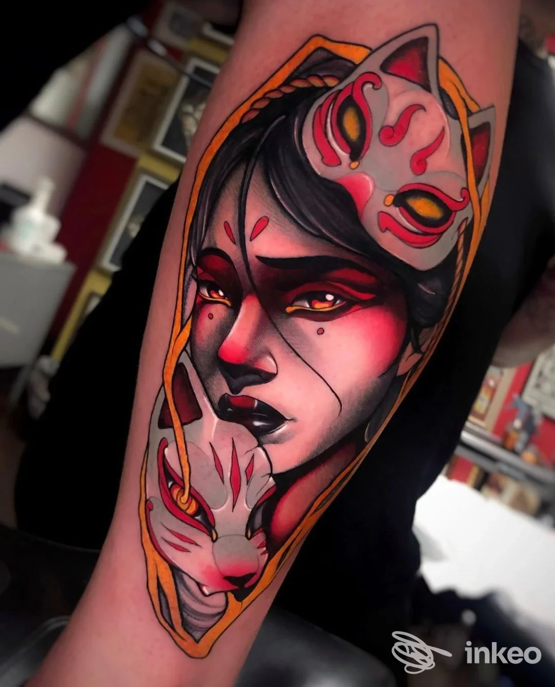 Tattoo a colori su braccio raffigurante una figura femminile con maschera, realizzata con linee fini e tonalità rosse, nere e gialle in stile tradizionale. Studio Santos Tattoo.