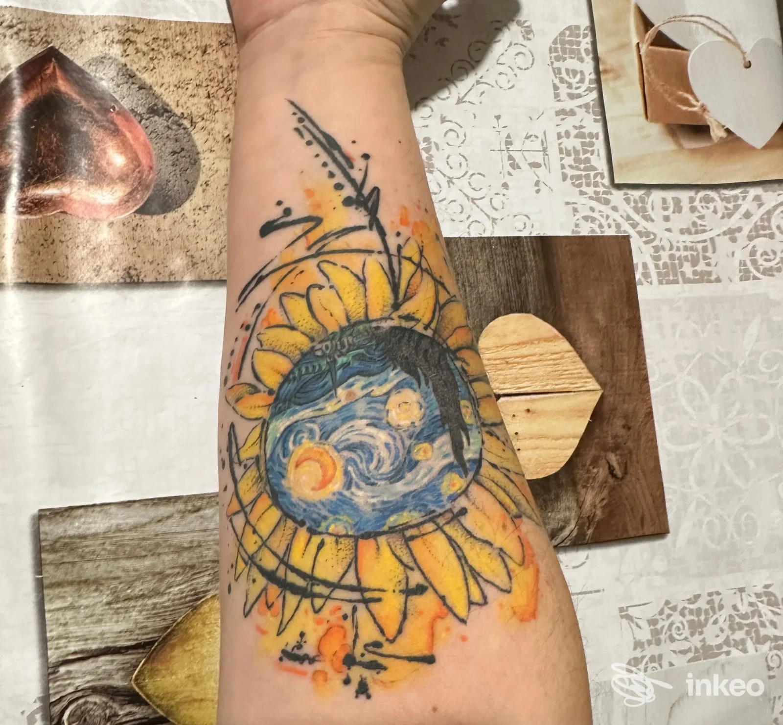 Tatuaggio colorato sull’avambraccio raffigurante un girasole con al centro un paesaggio marino e sole, eseguito da Art On Skin Tattoo Studio.