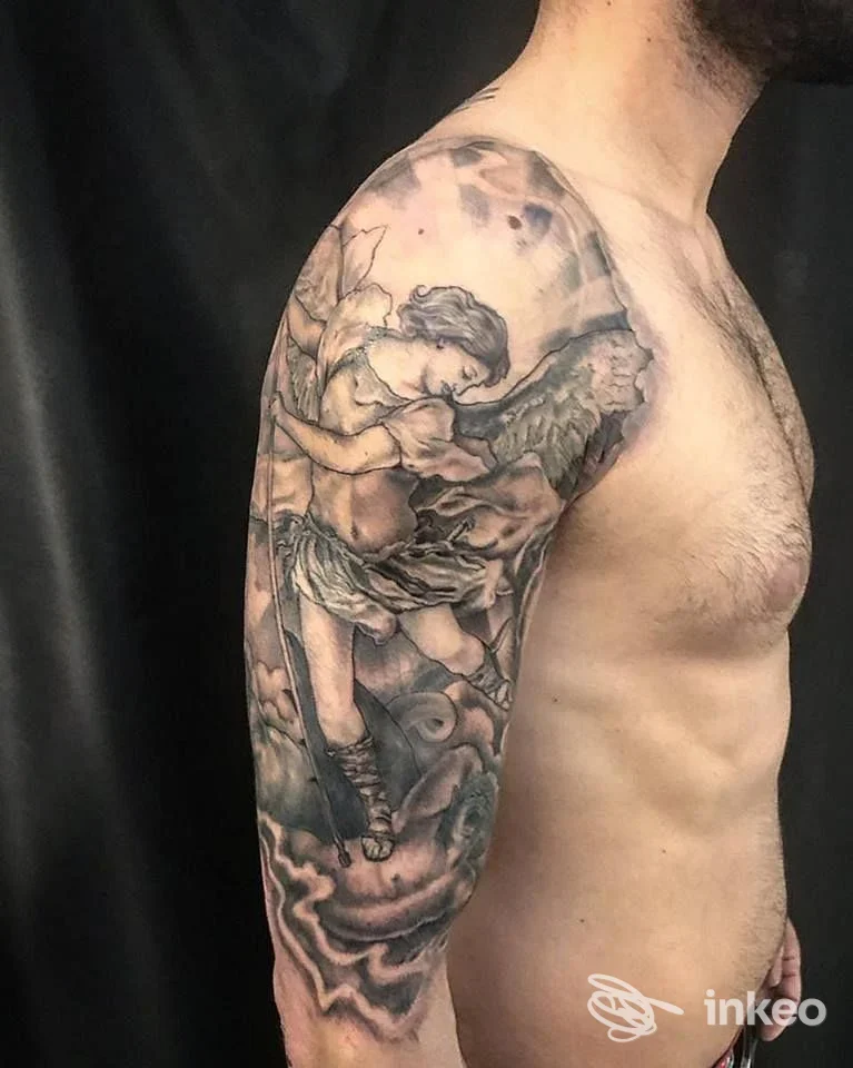 Braso sinistro con tatuaggio realistico a manica, raffigurazione angelica fra nuvole su pelle reale.