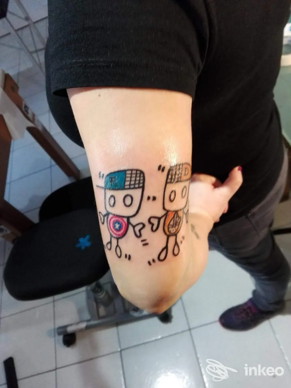 Tattoo visibile sul dorso del piede raffigurante due personaggi cartooneschi con dettagli colorati, scopo visivo chiaro. Studio B.Simo Tattoo Factory a Merate.