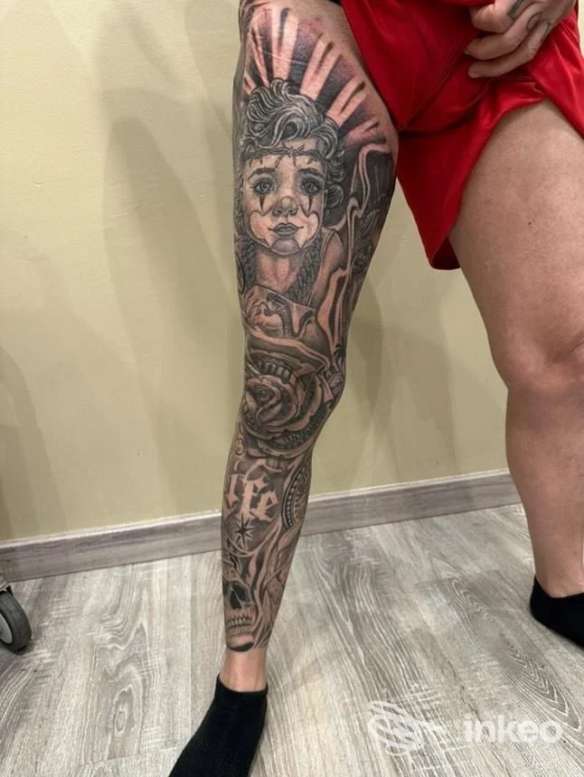 Gamba sinistra con tatuaggio realistico: ritratto e motivi floreali ben definiti, eseguito sulla pelle, Caduta su sfondo neutro, Rozzano Ink, Rozzano.