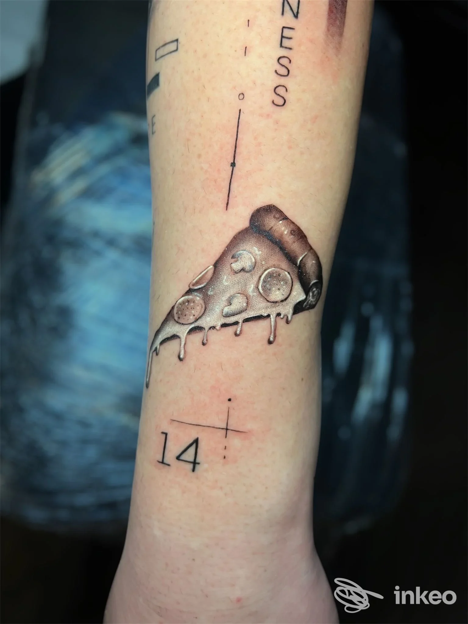 Avambraccio con tatuaggio realistico raffigurante una fetta di pizza che cola, accompagnata da linee e numeri; visibileuno studio One More Tattoo Studio.