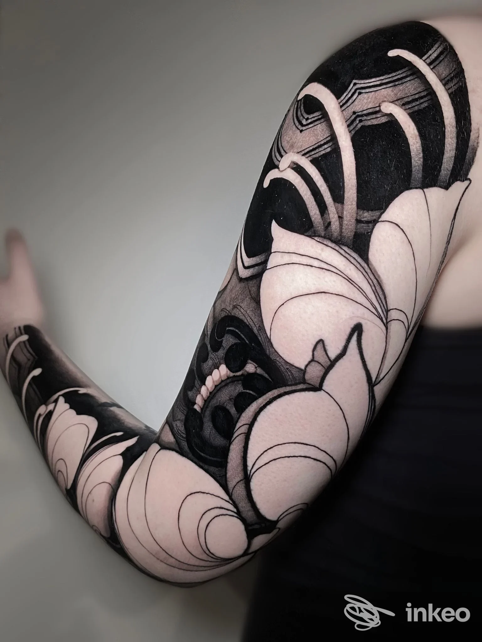 Tatuaggio sull'avambraccio in bianco e nero con motivi floreali, realizzato direttamente sulla pelle.