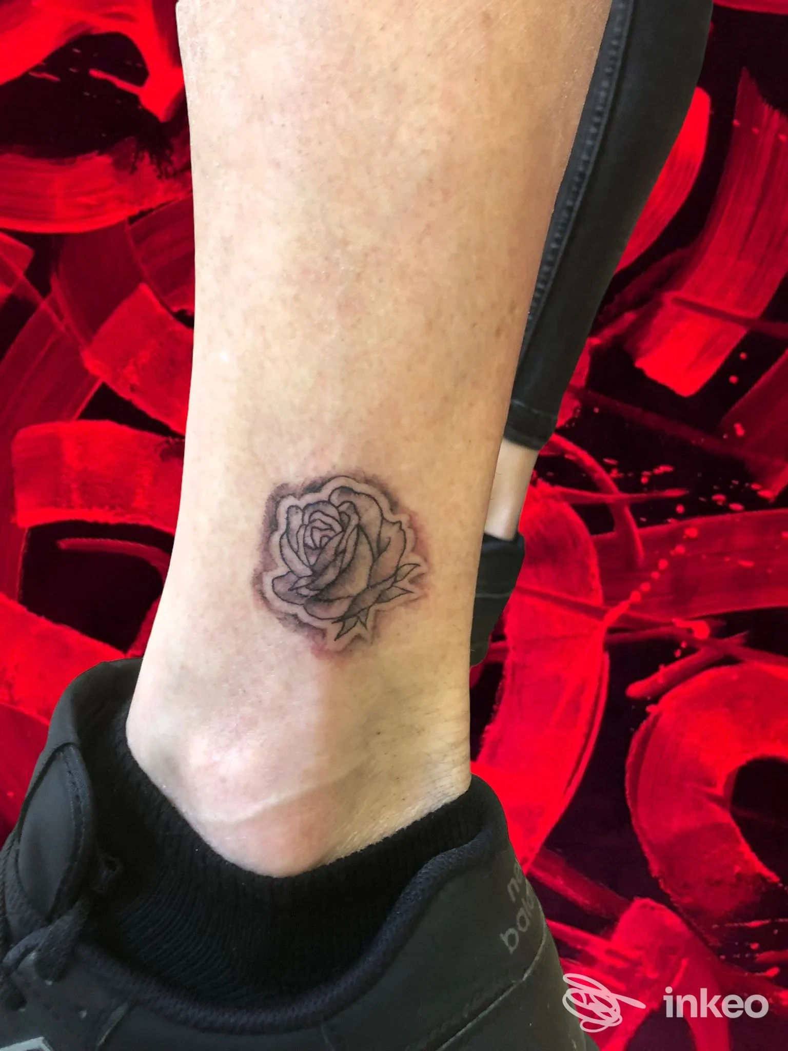 Tatuaggio vero di rosa sulla caviglia di una persona, eseguito direttamente sulla pelle.