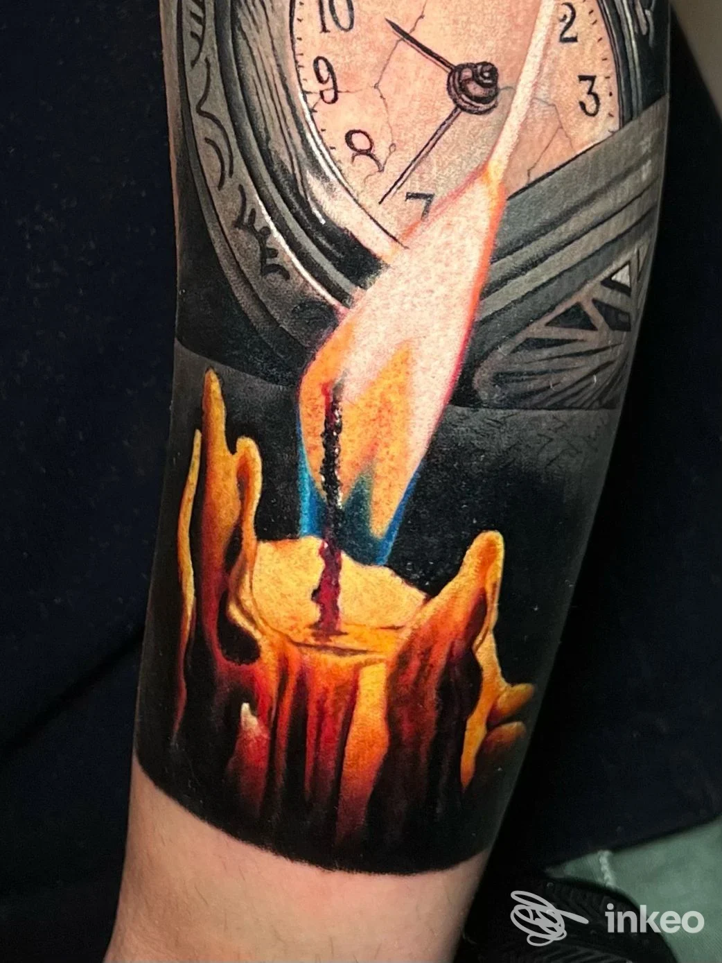 Tattoo realistico su avambraccio raffigurante una candela accesa davanti a un orologio, colori vividi e dettaglio di fiamma e cera.