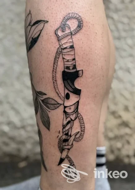 Tatuaggio su pelle della gamba raffigurante una lama avvolta in una corda, eseguito dallo studio F4to a Orzinuovi (BS).