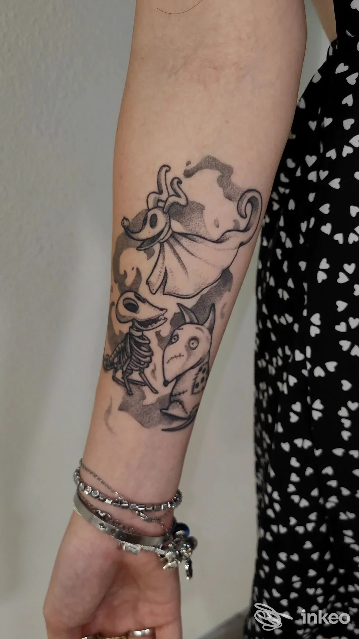 Braccio con tatuaggi in tonalità scure, raffiguranti creature astratte, visibile in primo piano