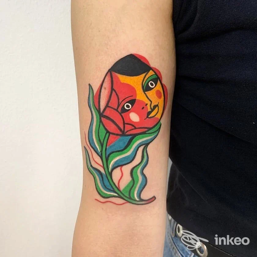 Tattoo colorato su braccio raffigurante forme astratte, inchiostro nero a contorno definito.