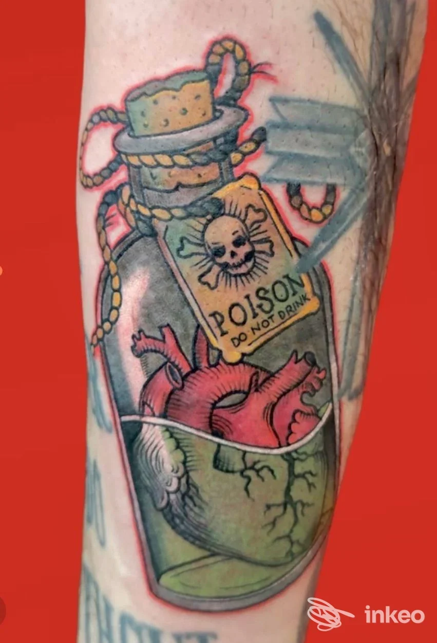 Tatuaggio su pelle raffigurante una bottiglia con etichetta pericolo, cuore all’interno di una bottiglia, nello stesso braccio.