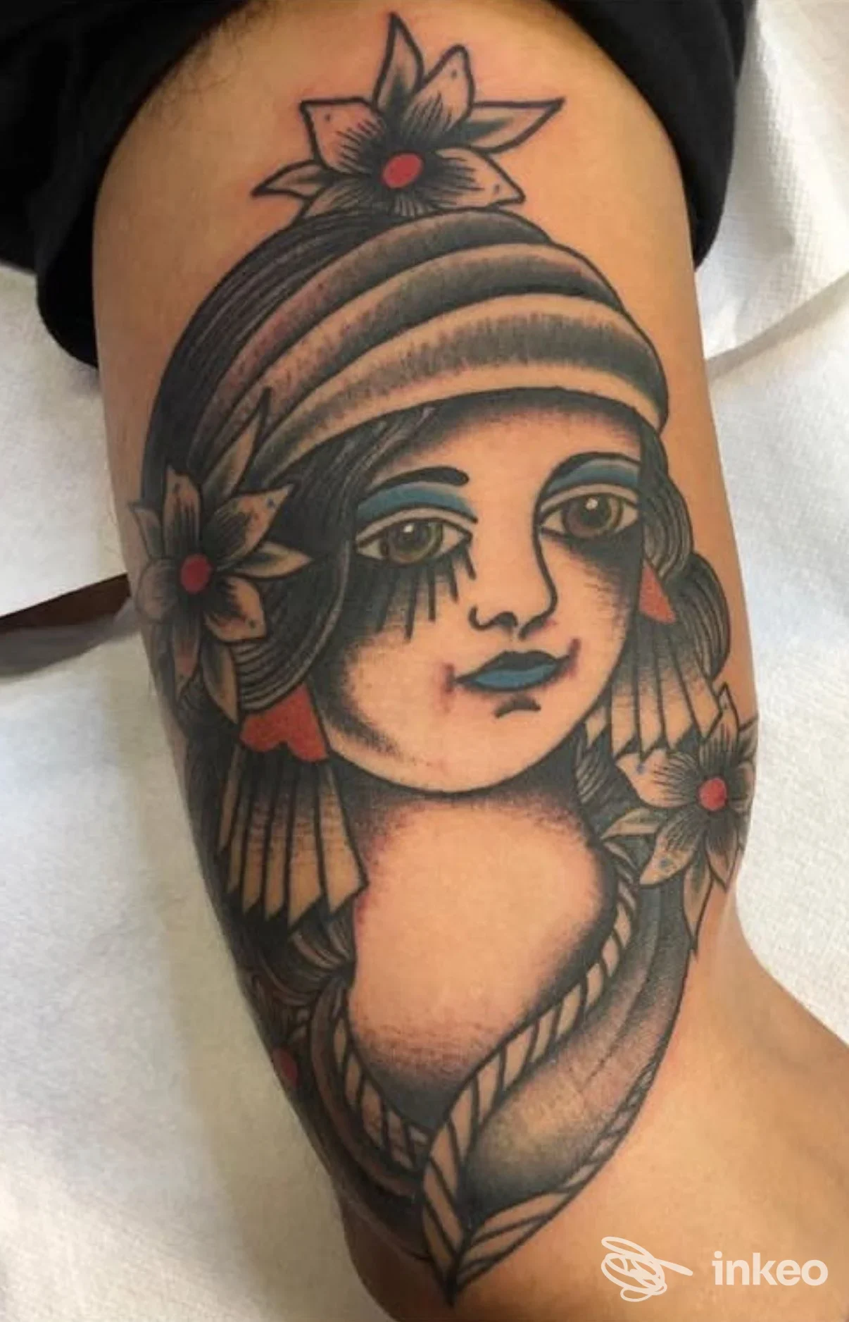 Tattoo su polpaccio raffigurante una donna stile grafico con capelli intrecciati e fiori, disegno in nero con riempimenti e dettagli bianchi.
